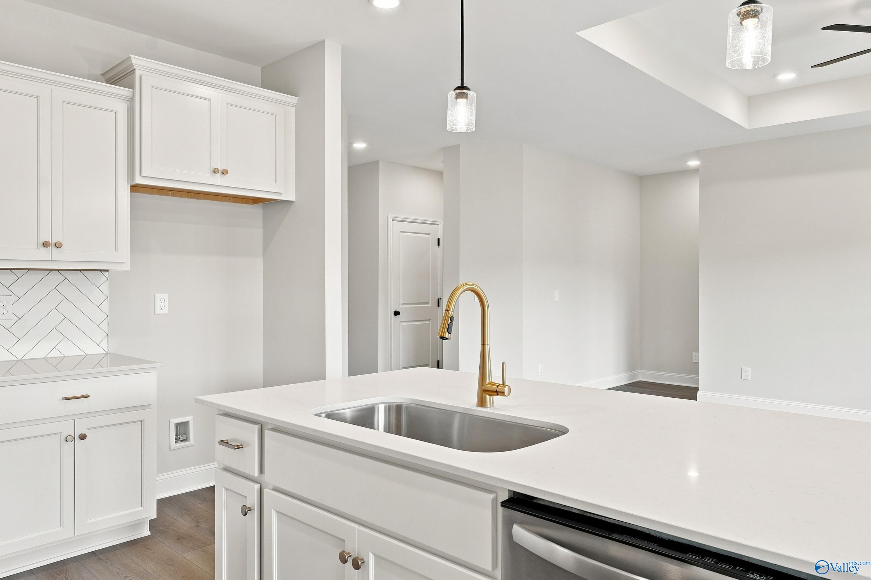 Modern kitchen island with quartz countertops and gold faucet in Asheville E floor plan, Forest Glen, Hazel Green, AL.