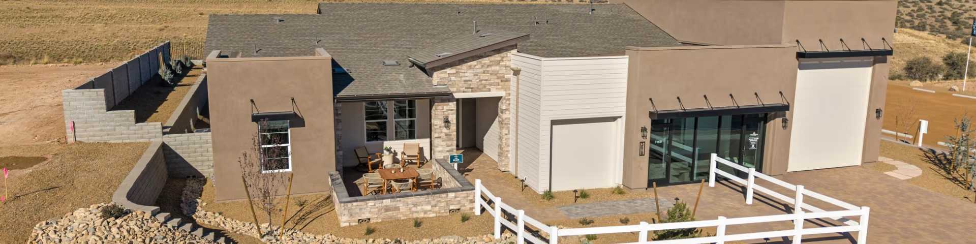 Contemporary Davidson Homes model home exterior at Hidden Hills in Prescott, AZ with a stone patio and white fence.