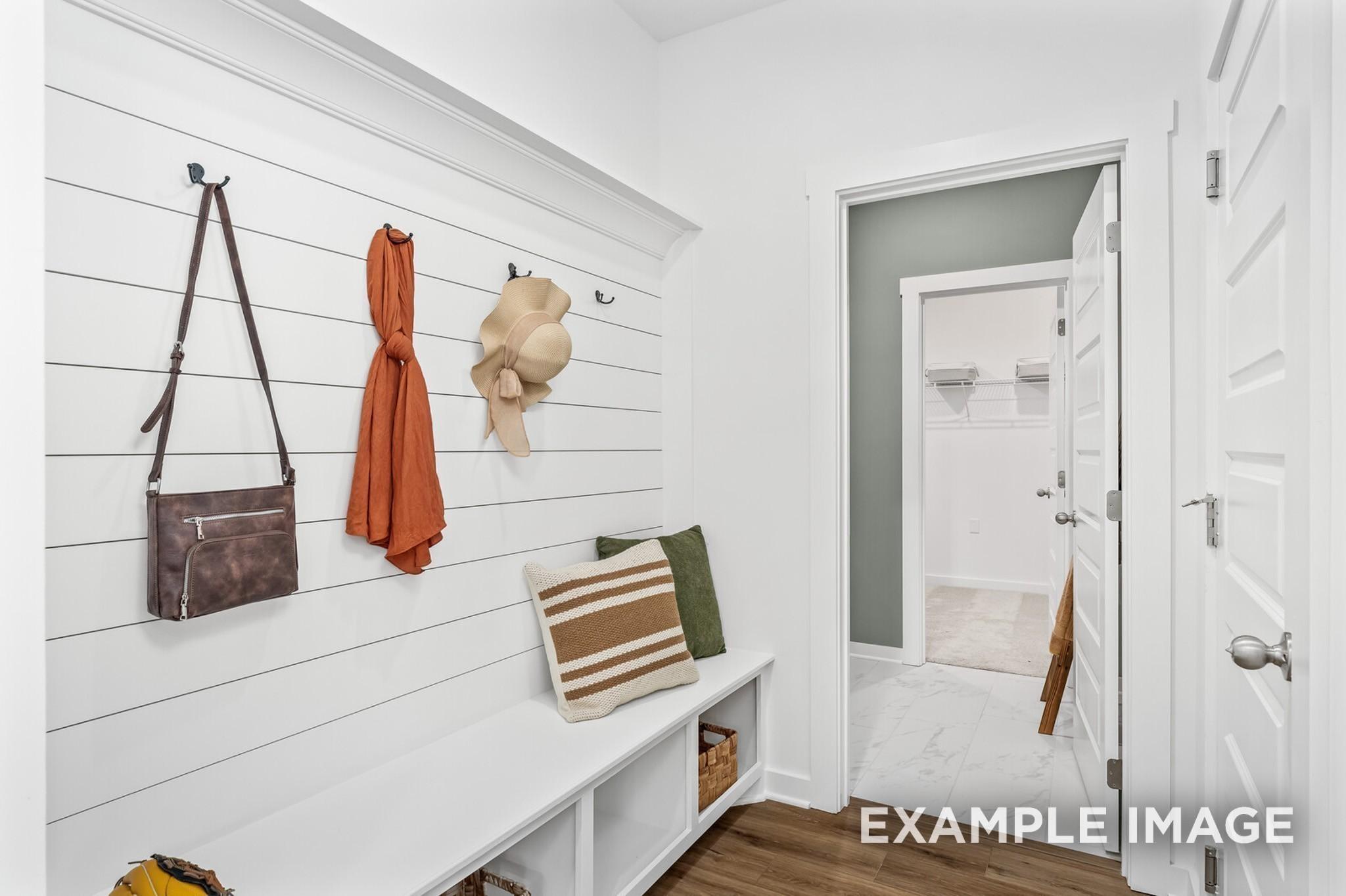 Mudroom bench with shiplap wall and coat hooks in The Ash A floor plan at Woods Crossing in Gallatin, Tennessee.