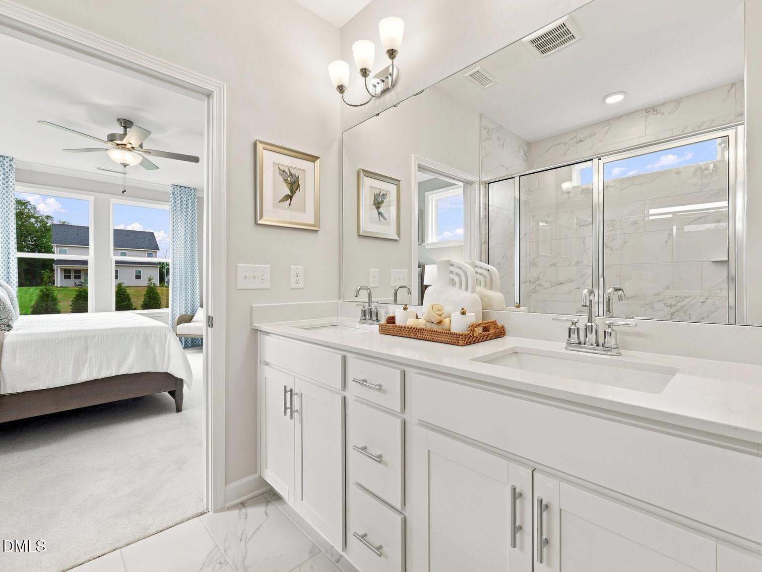 Modern primary bathroom with double vanity and tiled walk-in shower in The Daphne C home at Woodland Crossing, Zebulon, NC.
