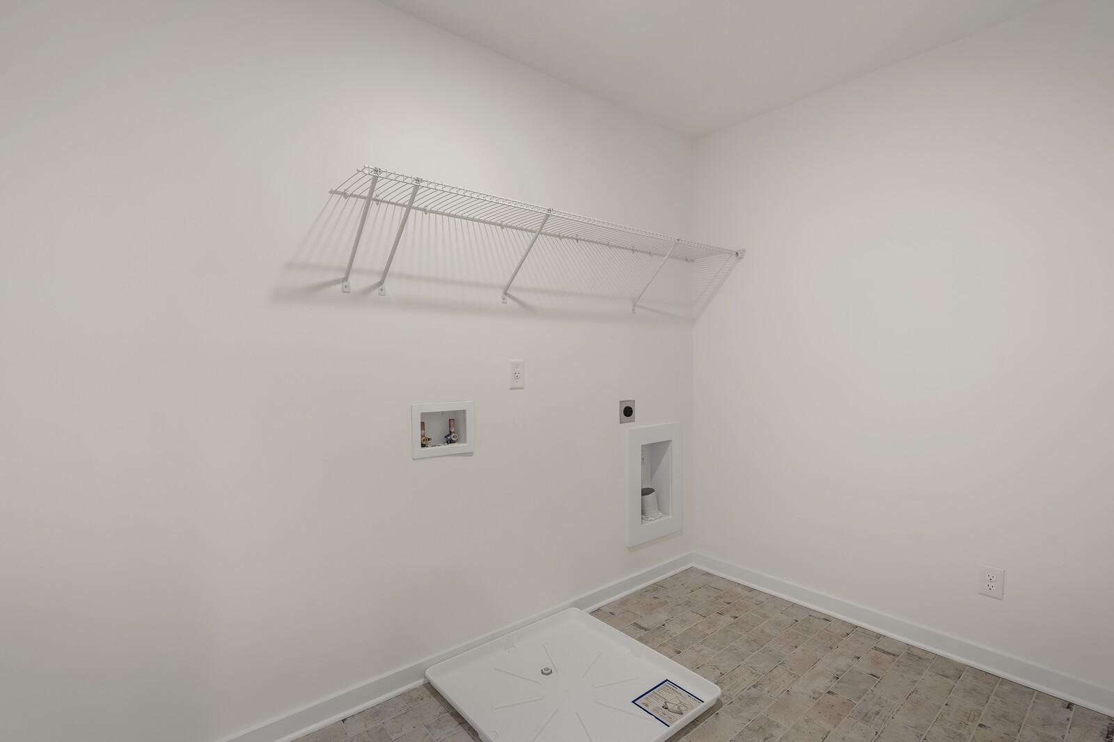 Bright laundry room with wire shelving, washer-dryer hookups, and tiled floor in Davidson Homes The Willow C, Gallatin, TN