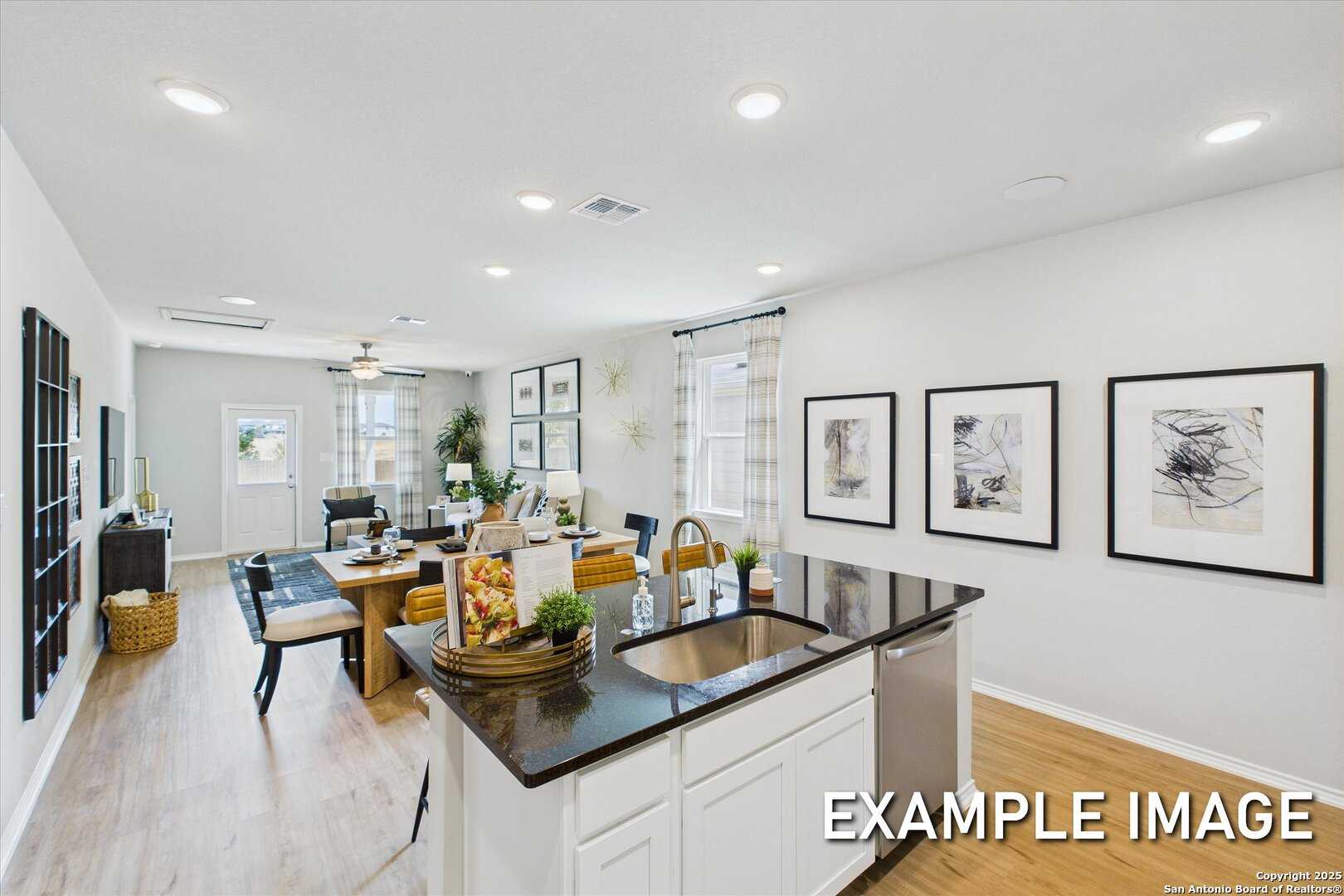 Open-concept kitchen with granite island, stainless dishwasher, and dining area in Davidson Homes The Sabine C, Agave, San Antonio