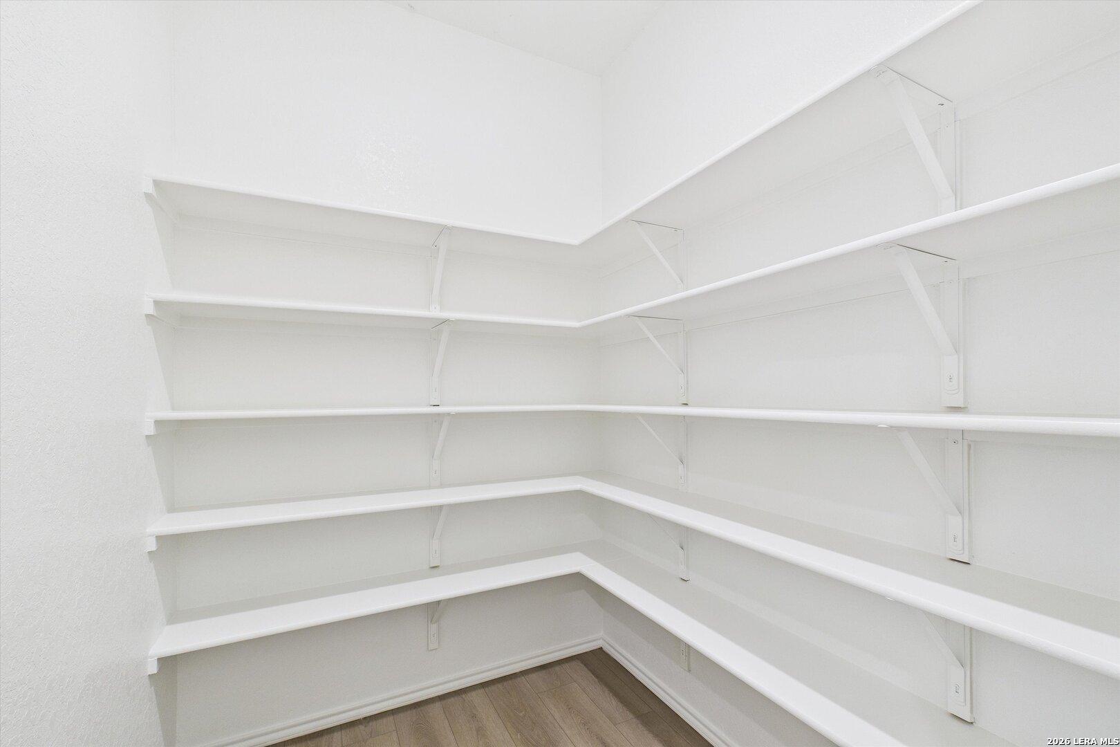 Spacious walk-in pantry with white corner shelving in Davidson Homes The Gillian B, San Antonio, Texas
