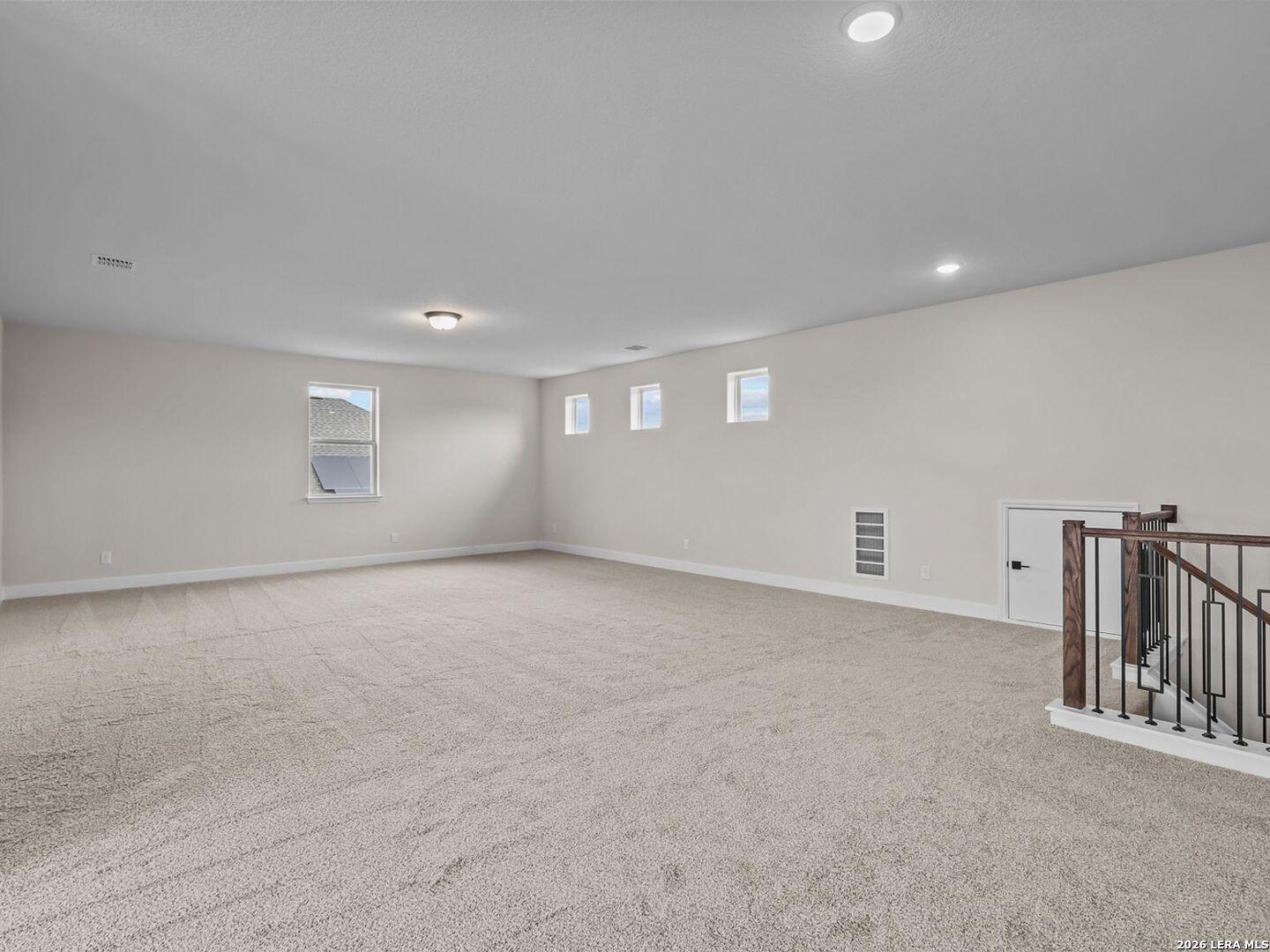 Spacious carpeted game room in The Belmont H floor plan by Davidson Homes in Potranco Oaks, Castroville, Texas.