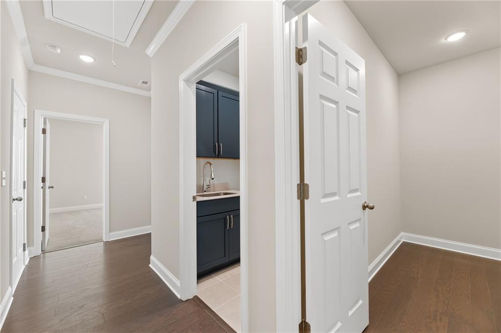 Bright hallway with butler's pantry, navy cabinets, sink in Davidson Homes The Harrison G, Hoschton, Georgia