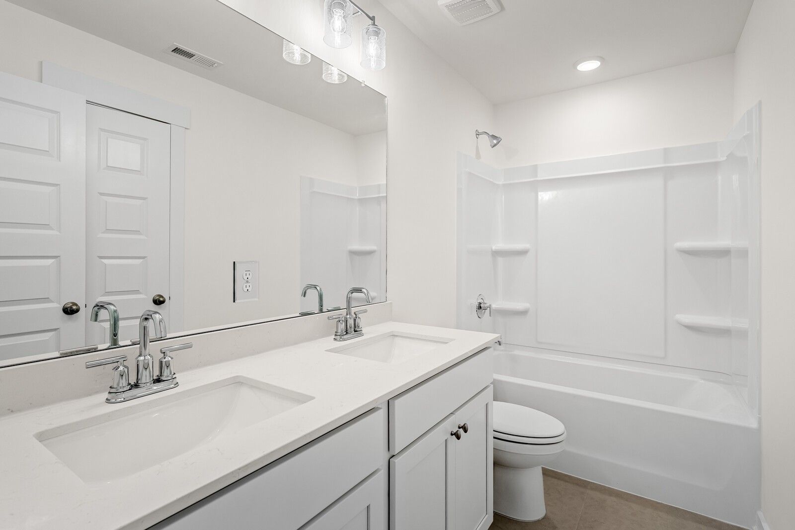 Bright white bathroom with double vanity, quartz counters, chrome faucets, tub/shower combo in Davidson Homes Ridgeport D, Mt. Juliet TN