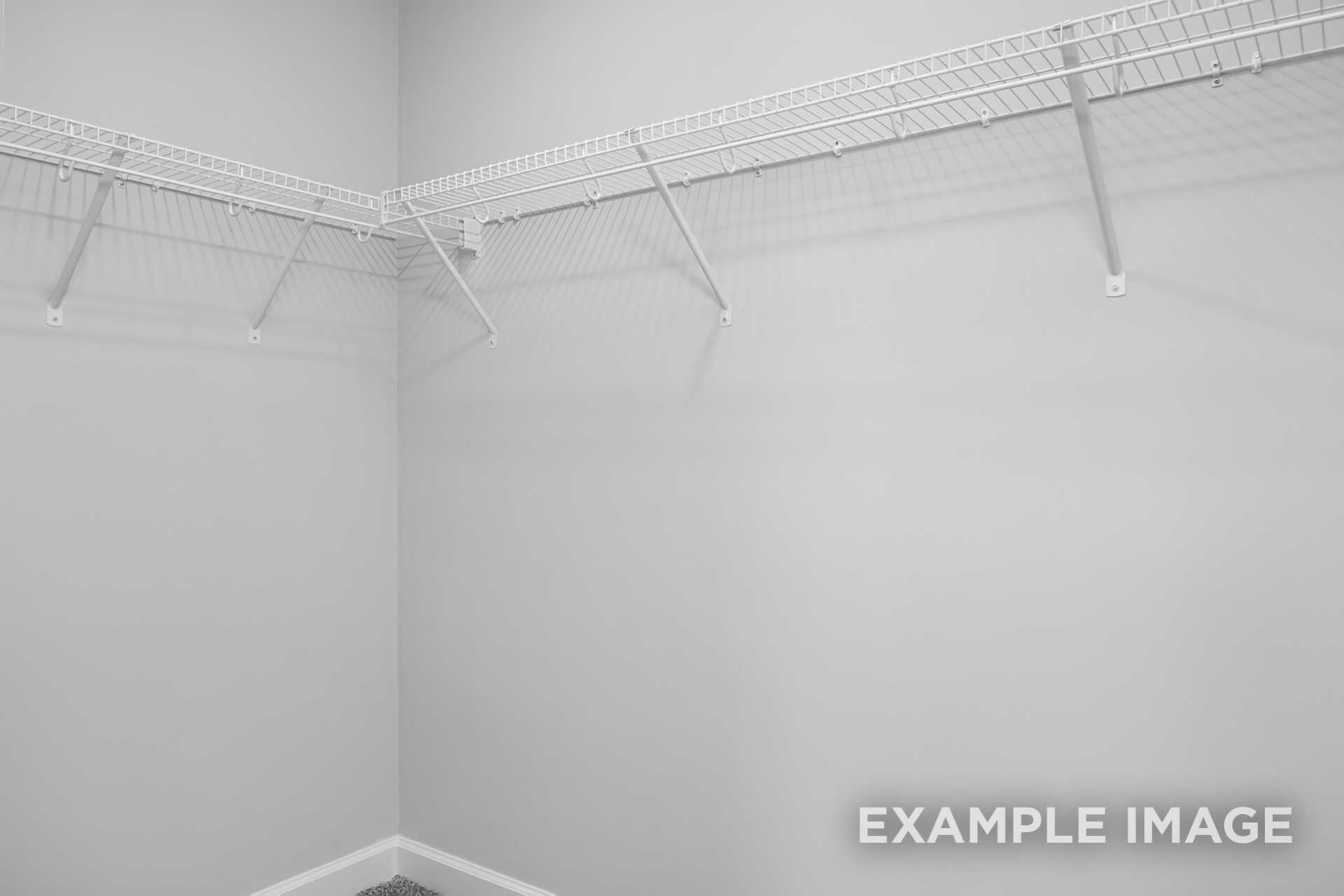 Spacious walk-in closet in The Preston B featuring white wire shelving along gray walls