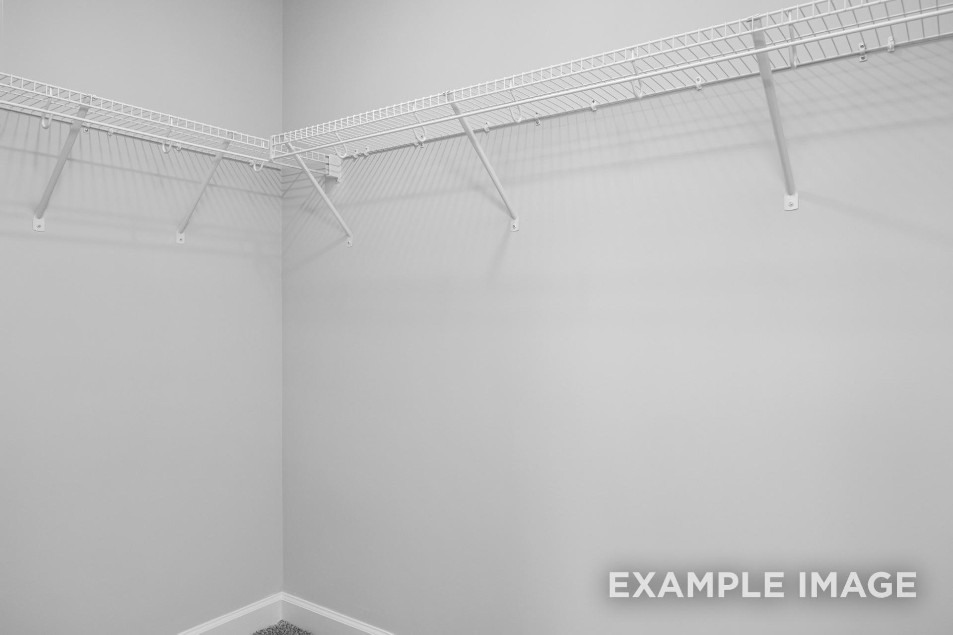 Spacious walk-in closet in The Preston B featuring white wire shelving along gray walls
