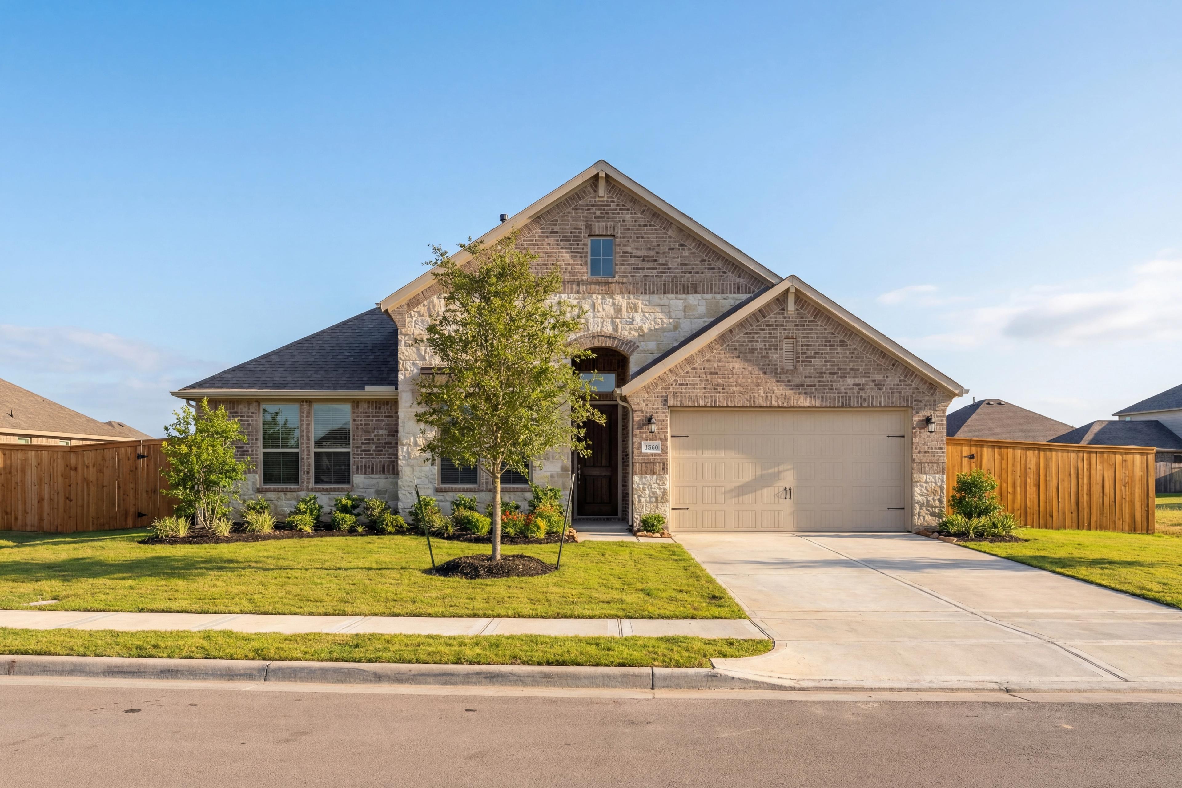 The Edward B single-story home elevation featuring brick and stone facade, arched entry, 2-car garage, and landscaped yard in Rosharon Texas