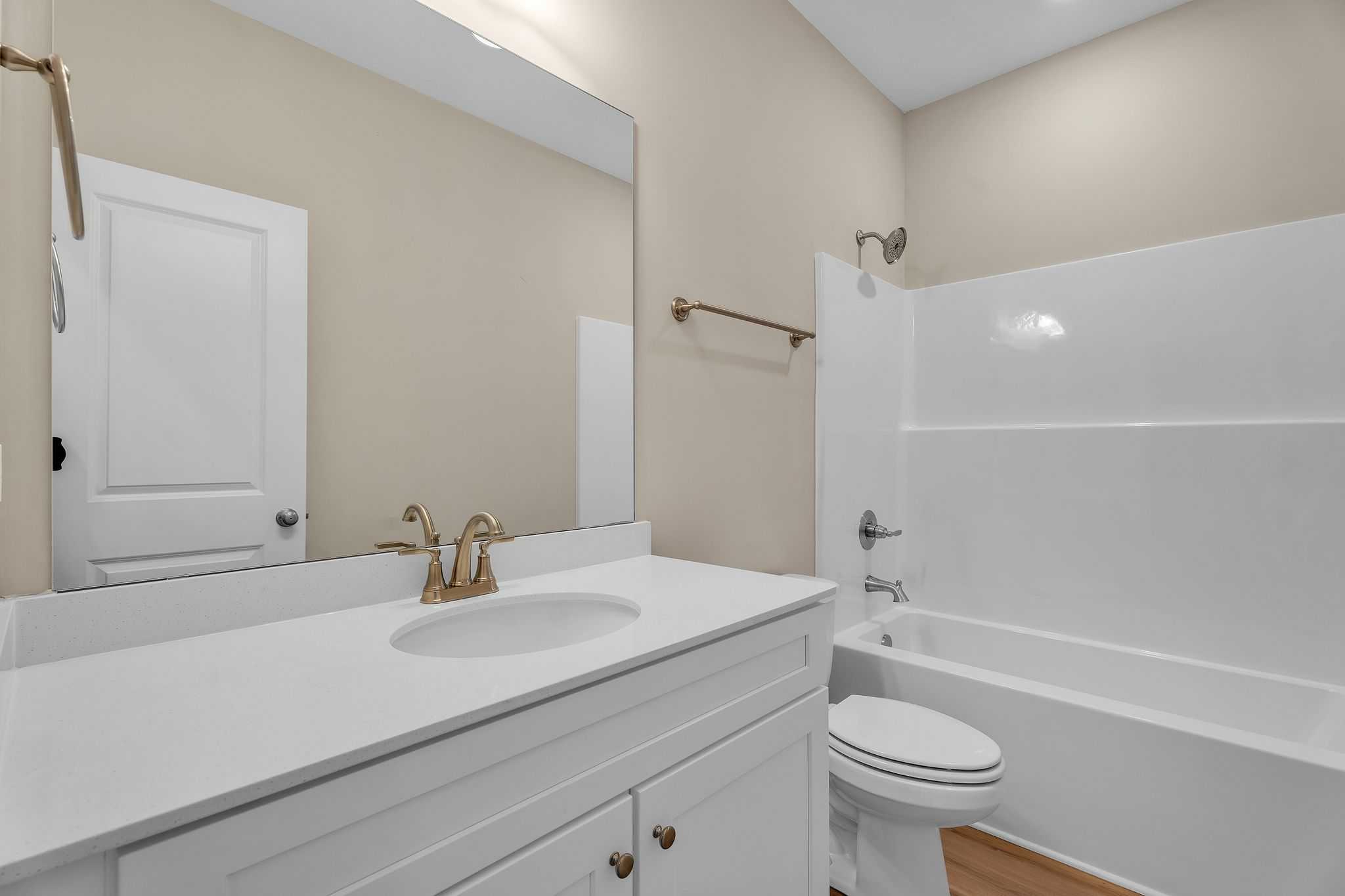 Modern bathroom in Anderson Lakes Opelika AL with beige walls, white vanity, tub shower combo by Davidson Homes