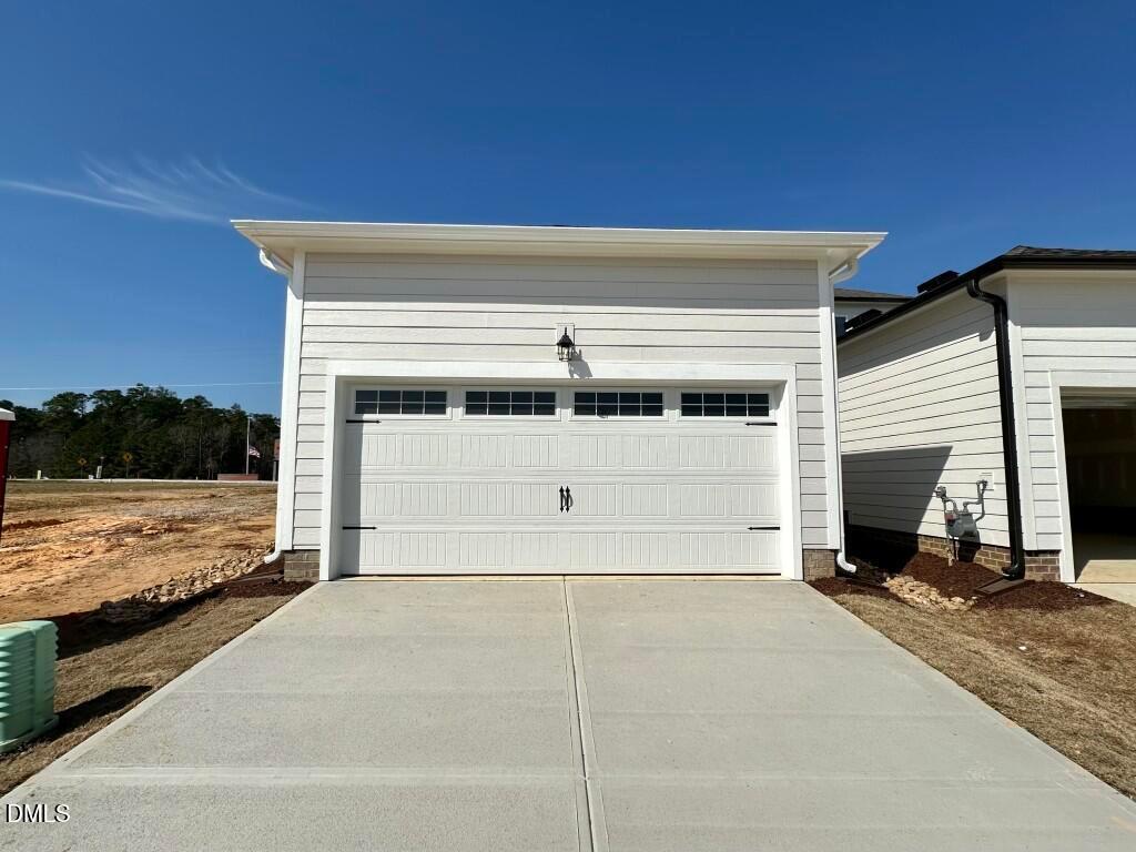 White two-car garage with paneled doors and concrete driveway in new Davidson Homes The Burke, Knightdale, NC