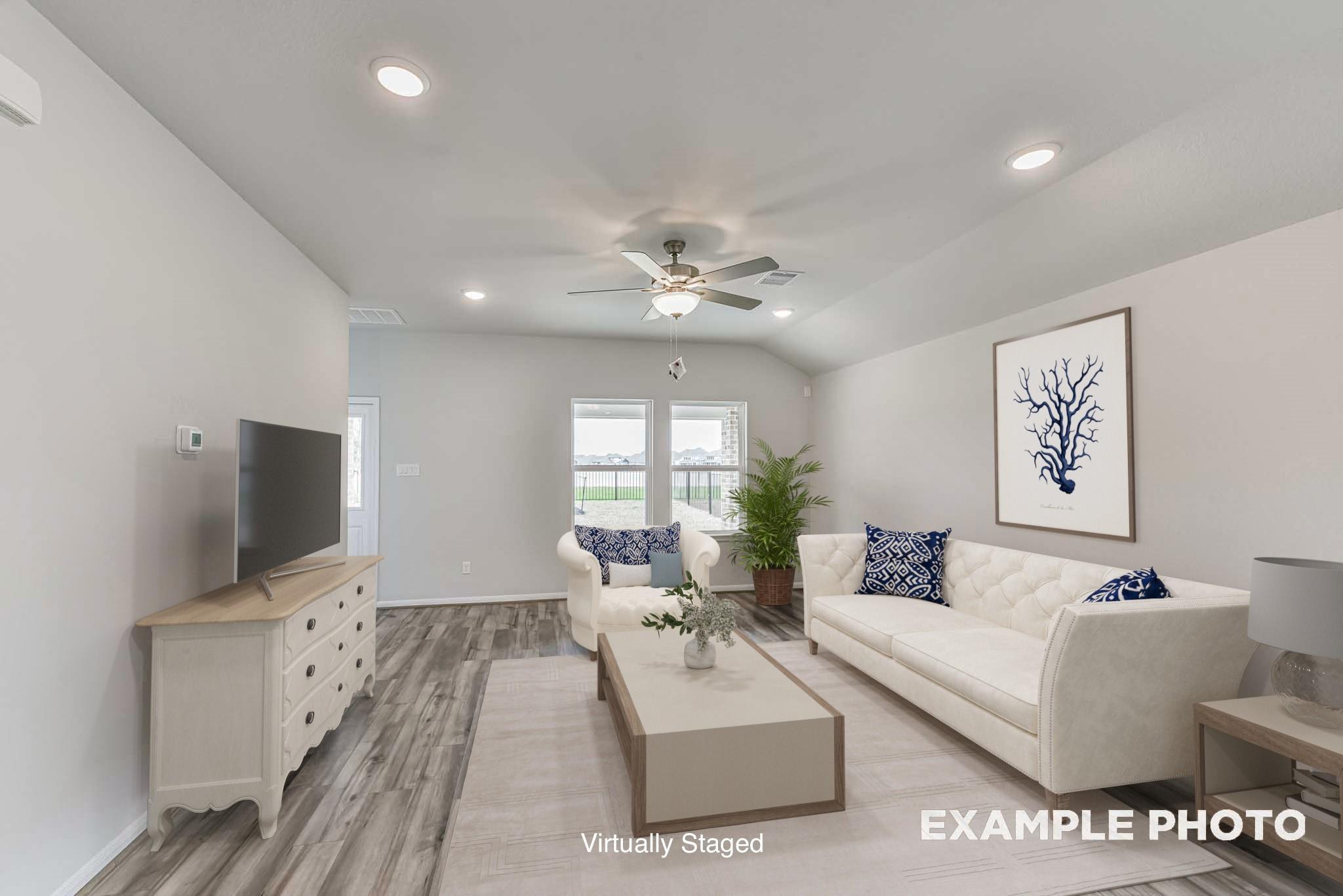 Virtually staged living room with white sofa and grey wood-look flooring in The Blanco E floor plan at Windmill Estates.