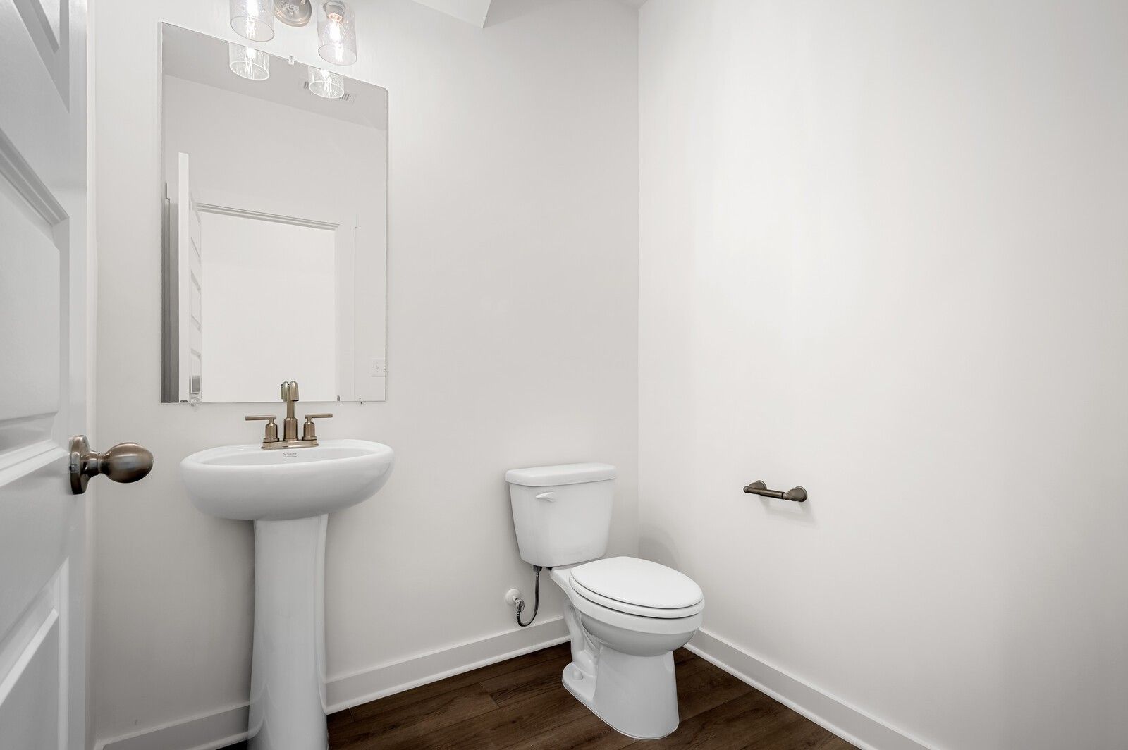 Modern powder room with pedestal sink and wood-look flooring in The Logan C floor plan at Calista Farms, White House, TN.