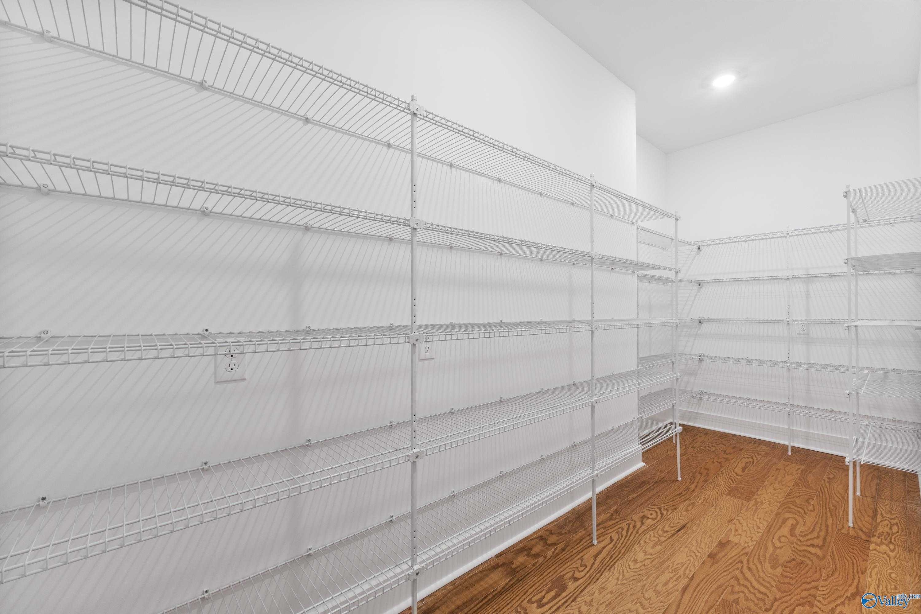 Spacious walk-in closet with white wire shelving and hardwood floors in Davidson Homes The Arcadia, Riverton Preserve, Huntsville