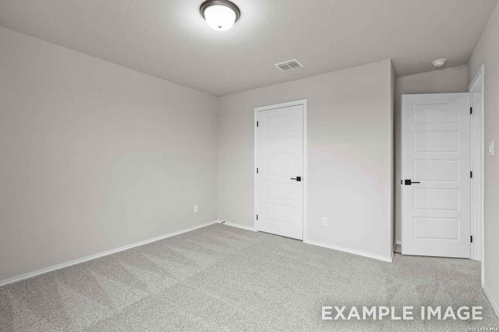 Empty bedroom with gray carpet, neutral walls, and white doors in Davidson Homes The Murray H plan, Converse, TX