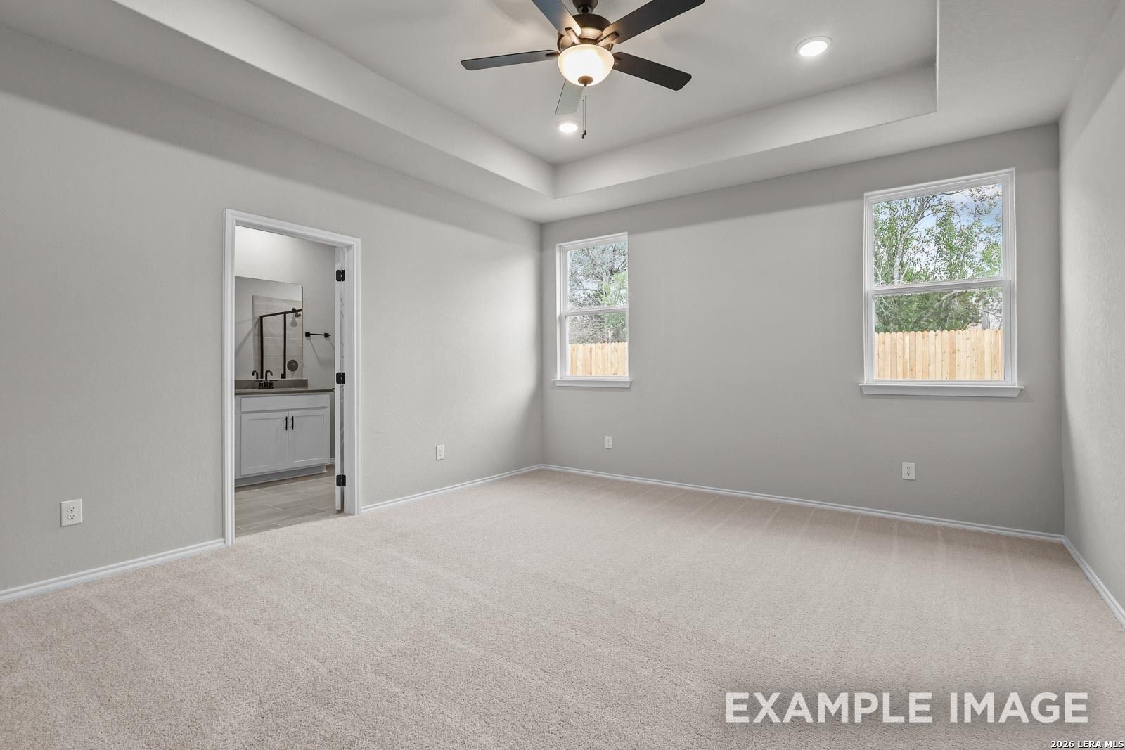 Spacious primary bedroom with tray ceiling and en-suite bath in The Glenwood E floor plan, Royal Crest, San Antonio.