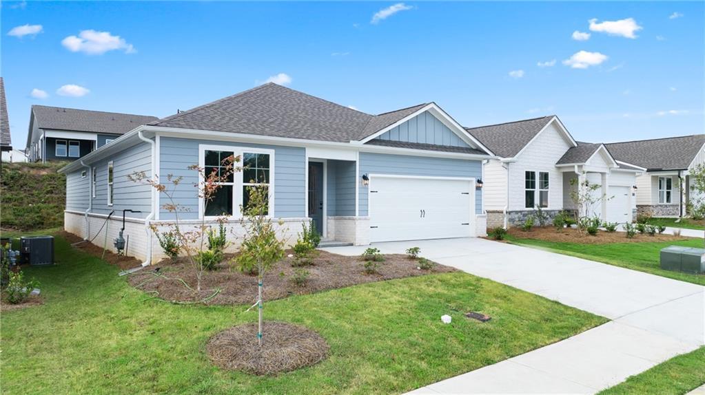 Single-story blue home with 2-car garage, driveway, and landscaped yard in Kelly Preserve, Loganville, Georgia by Davidson Homes