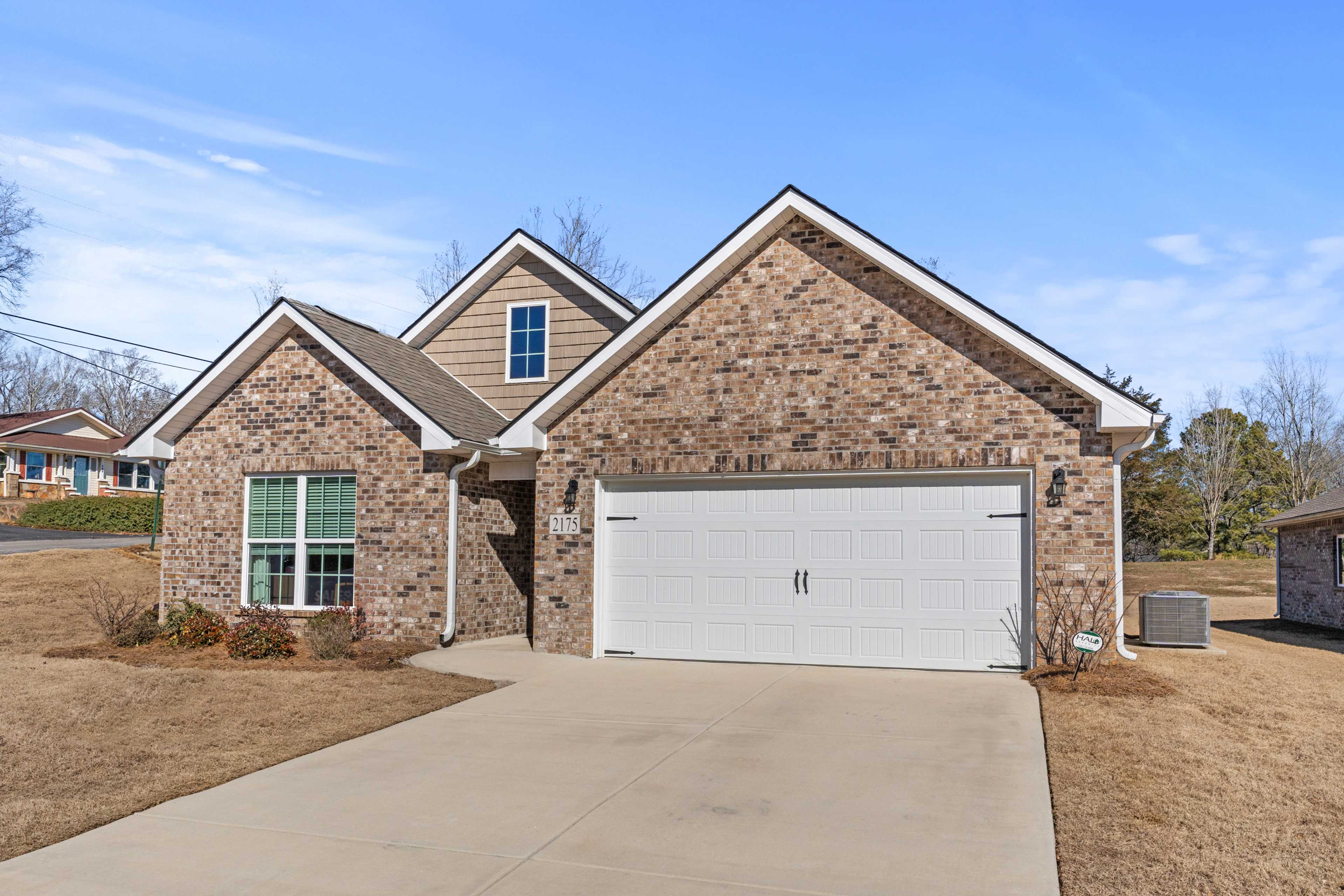 Brick ranch home exterior at Noble Ridge in Cullman Alabama with brick facade gabled roof white garage and concrete driveway