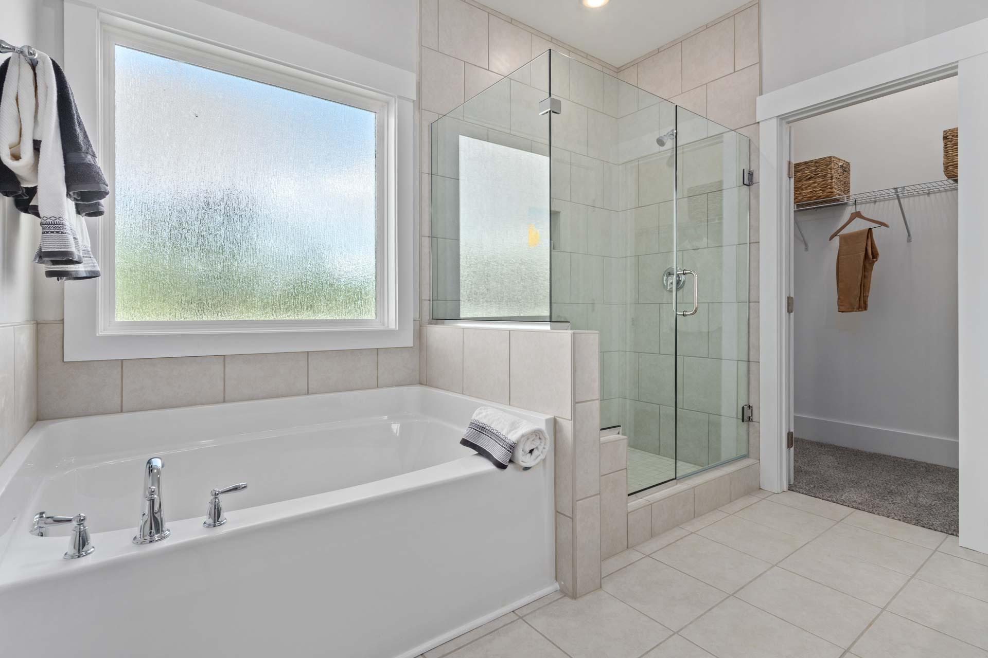 Spacious master bathroom at Blue Spring in Huntsville Alabama with glass shower, freestanding tub, subway tiles and walk-in closet