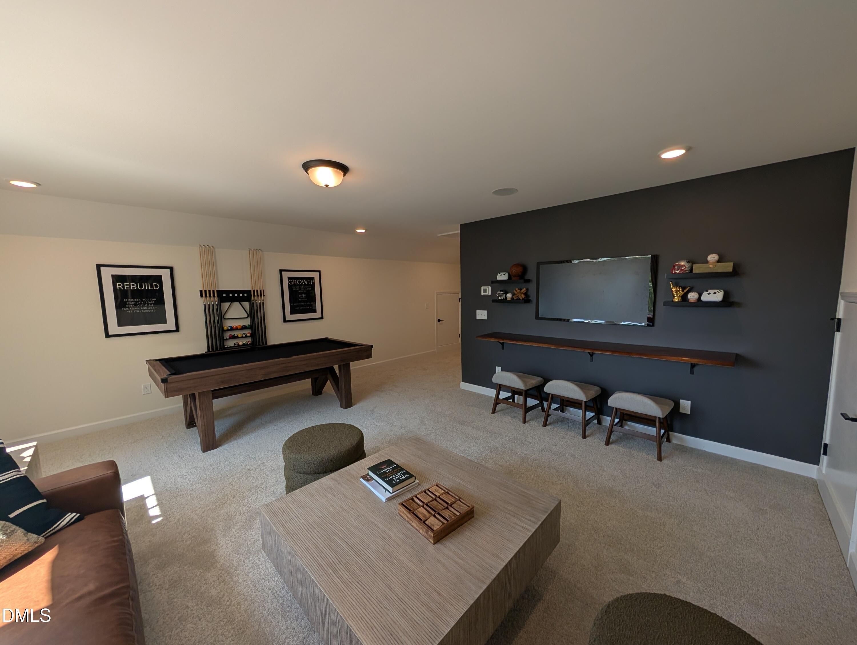 Spacious game room with pool table and media wall in The Aspen B floor plan at Wendell Ridge, Wendell, North Carolina.