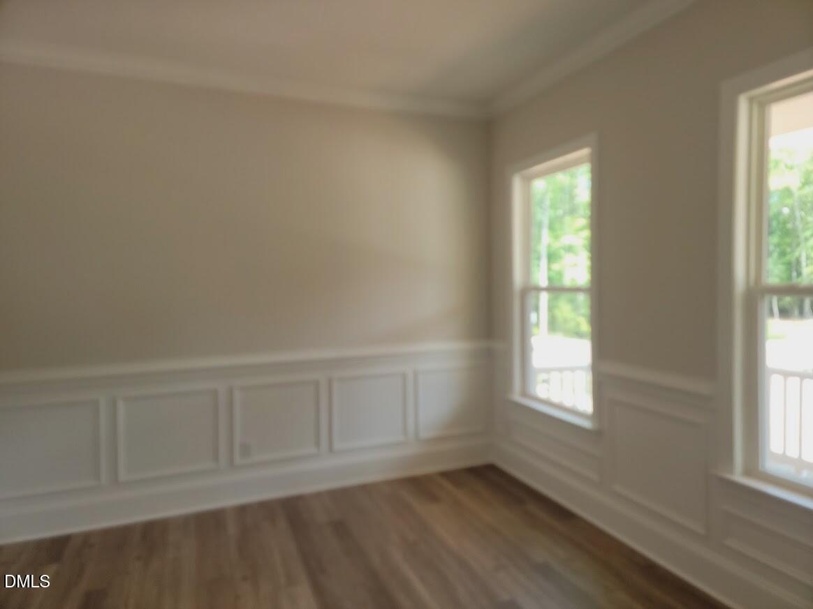 Bright dining room with wainscoting, hardwood floors, and large windows in Davidson Homes Magnolia II B, Wake Forest, NC