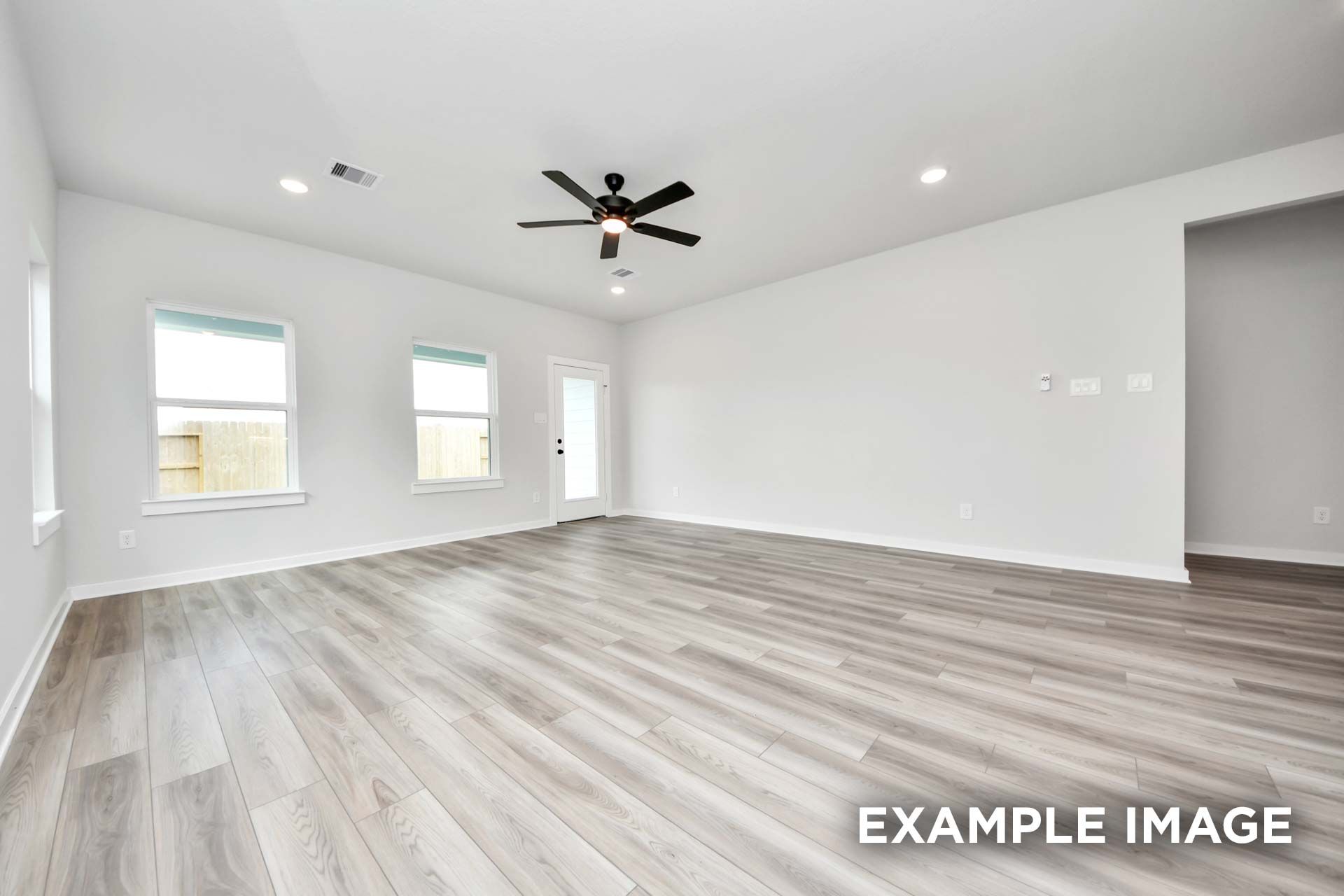 Spacious open-concept living area in The Sorrento featuring modern light wood flooring and recessed lighting.