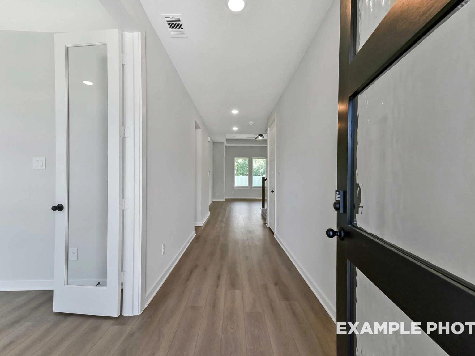 Bright entryway and hallway with wood-style flooring in The Sequoia C floor plan at Sundance Cove, Crosby, Texas.
