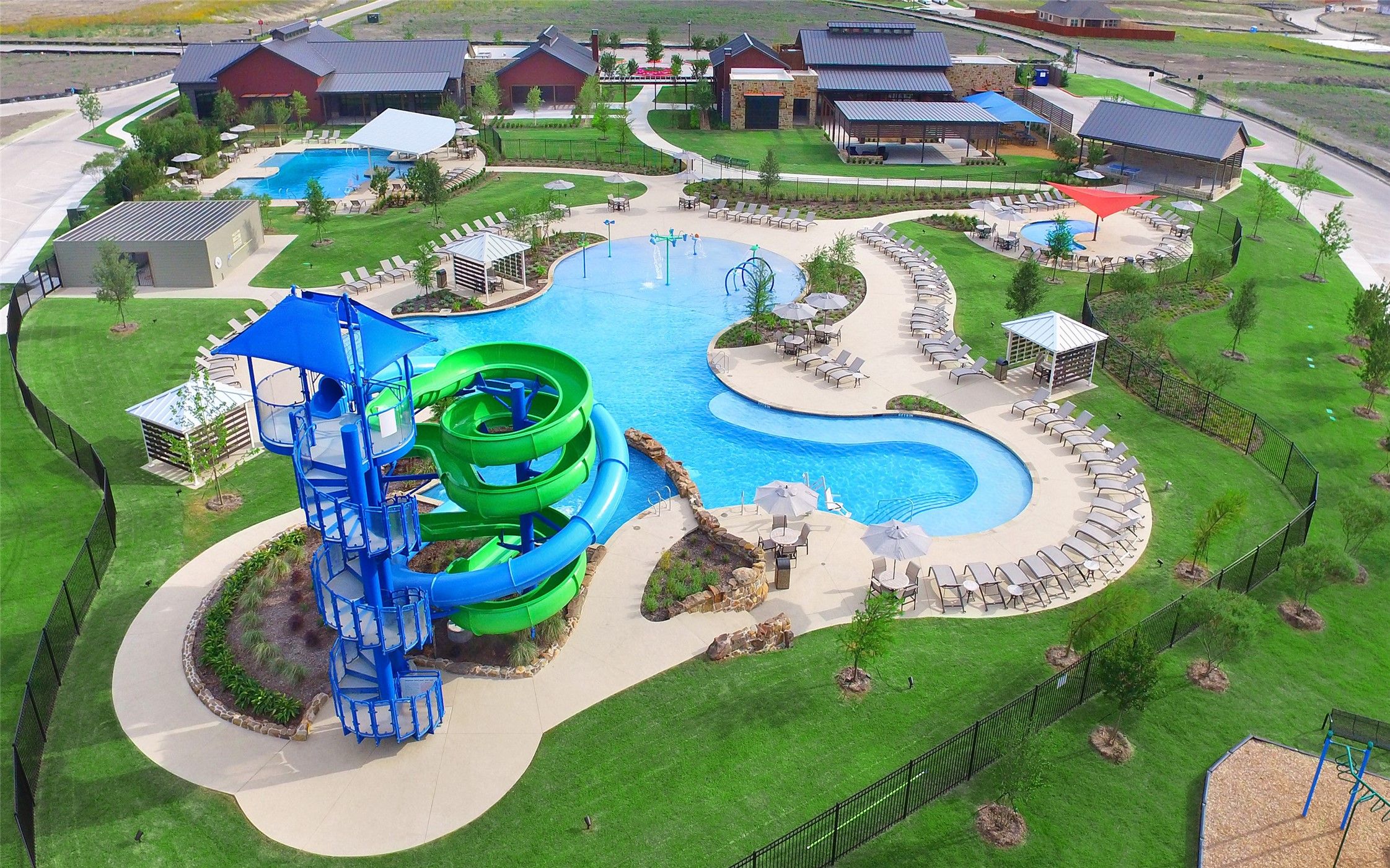 Aerial view of community swimming pool with water slide at Heartland, Texas, near Davidson Homes for sale.