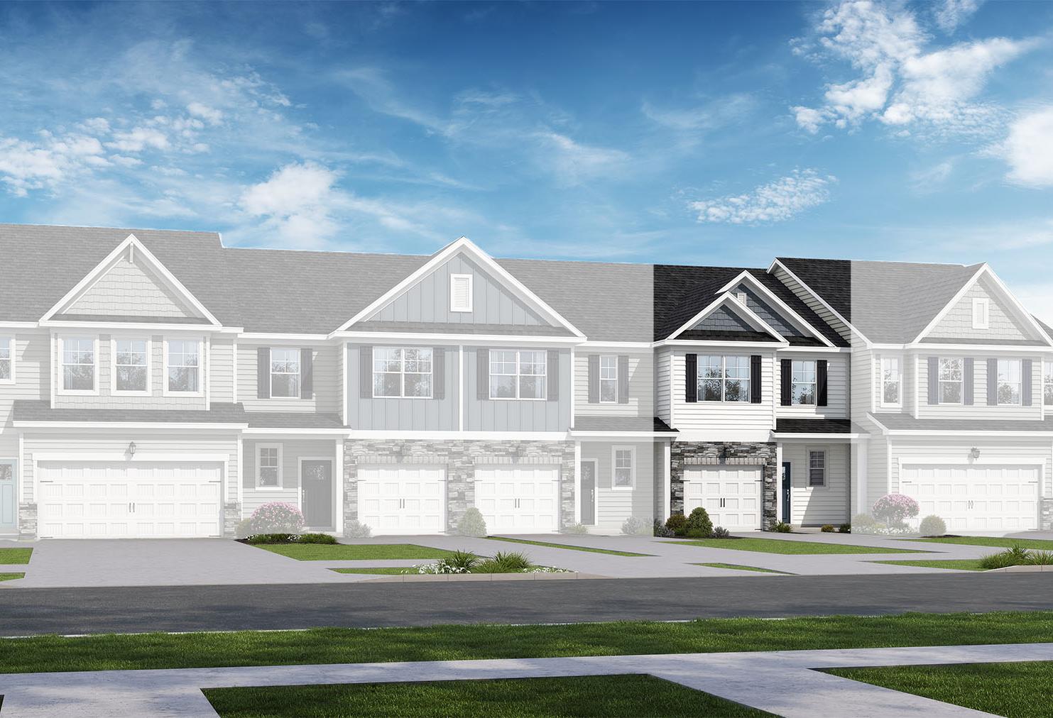 Modern 2-story townhome row in The Graham design by Davidson Homes, featuring white siding, black accents, garages, and lush landscaping in Lillington, NC