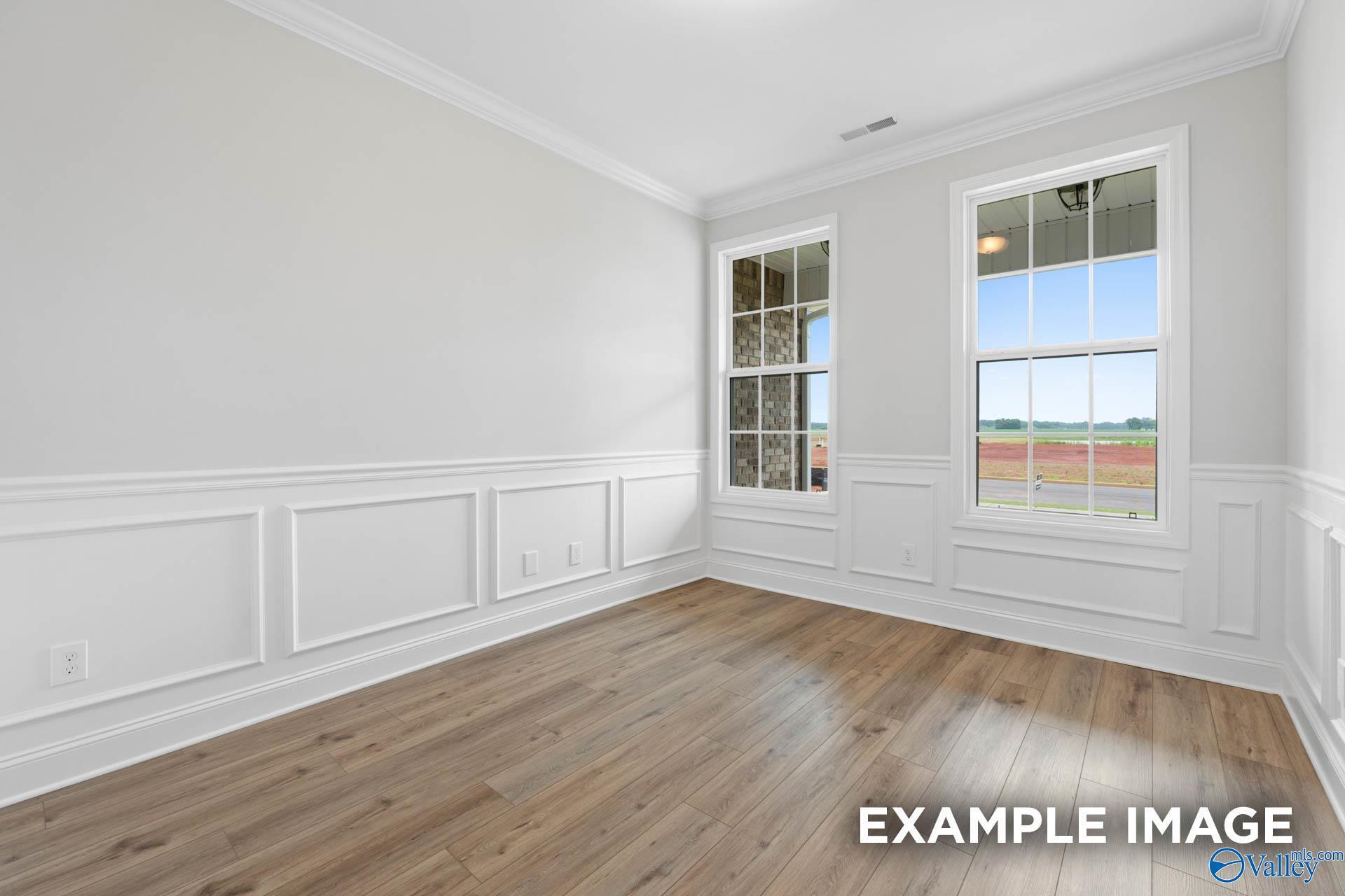 Bright room with white wainscoting and wood-look flooring in The Rockford floor plan at Pikes Ridge, Meridianville, AL.