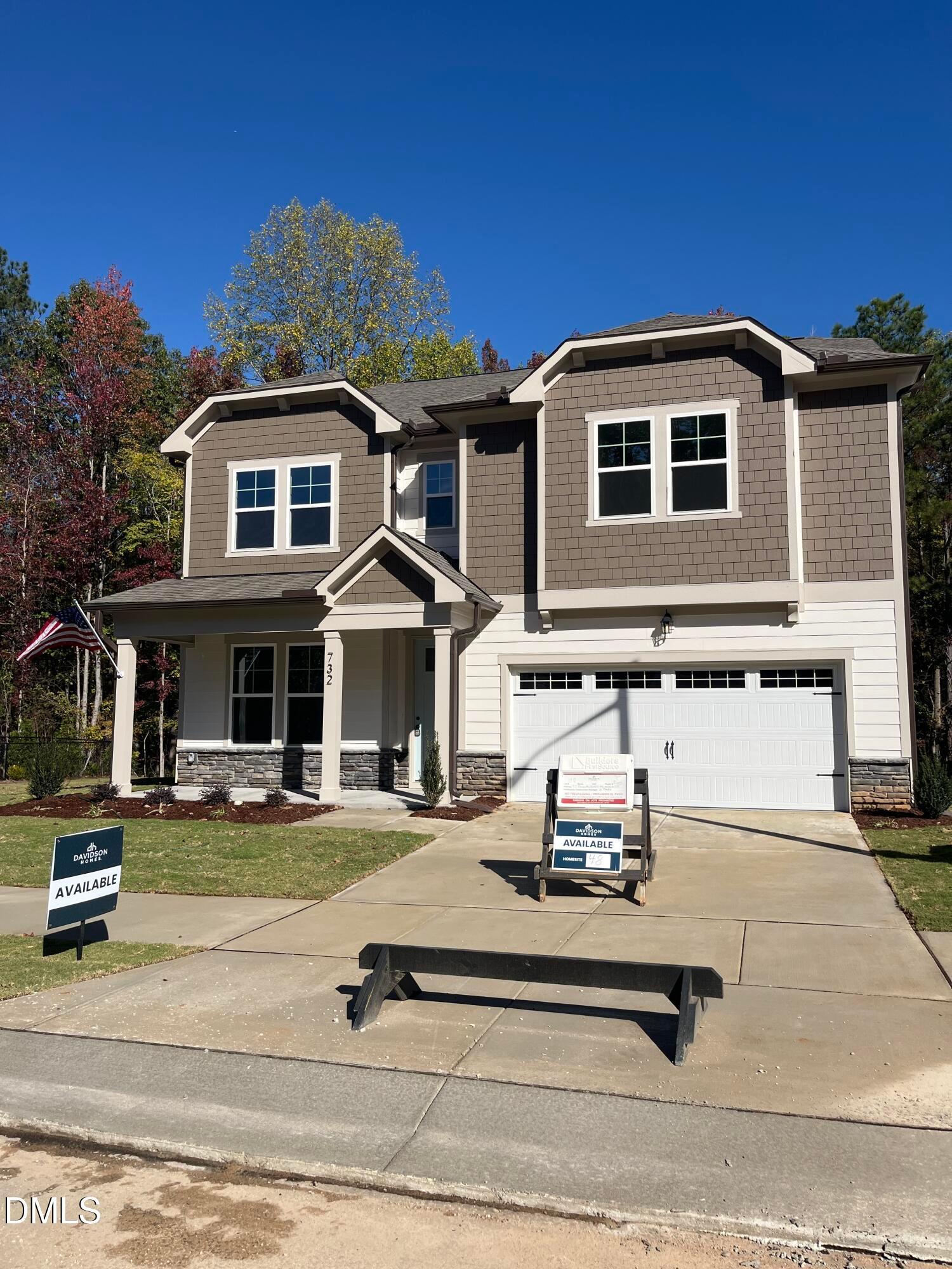 Two-story brown and beige home exterior with covered porch, 2-car garage, and Davidson Homes available sign in Wake Forest, NC