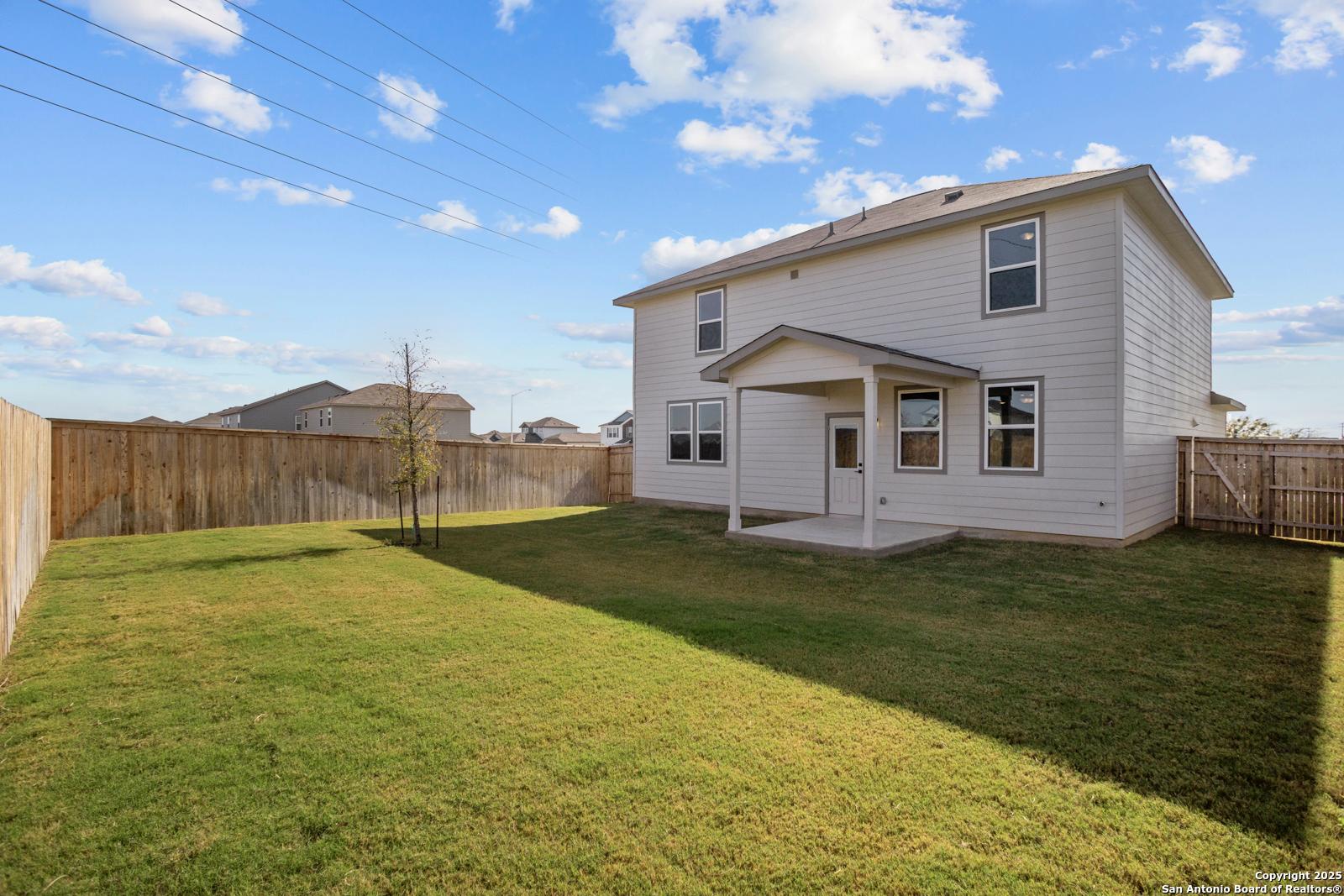 Covered back patio and fenced grassy backyard in 2-story Davidson Homes The Douglas C, Hannah Heights, Seguin, Texas
