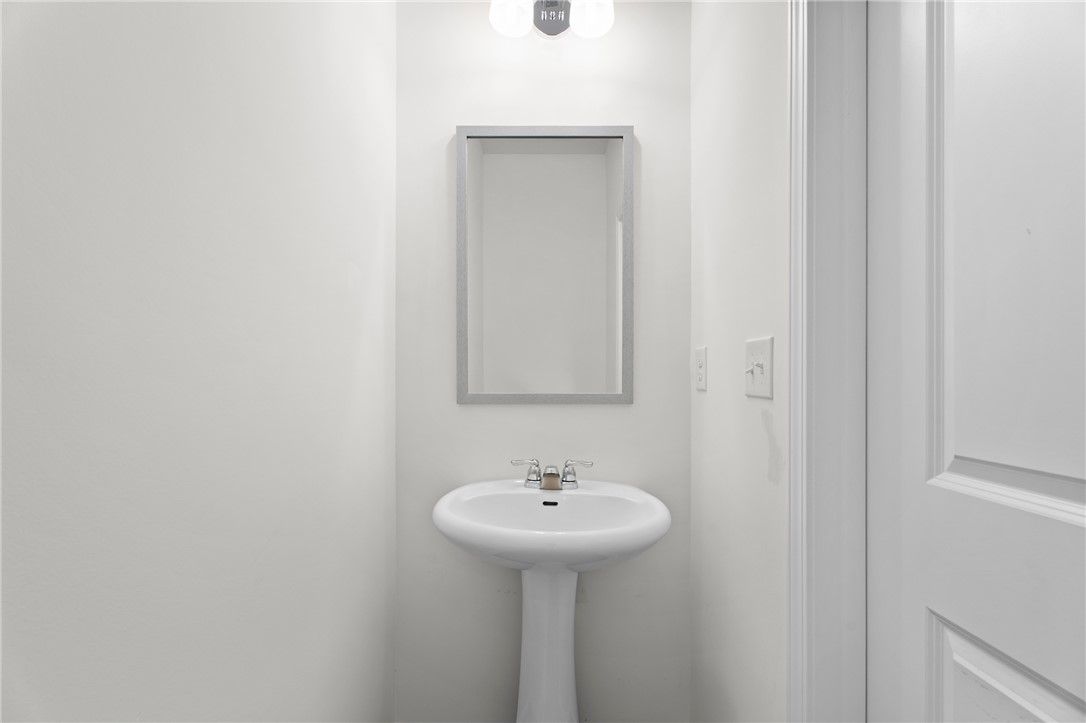 Modern half-bath with pedestal sink and mirror in The Stella D floor plan by Evermore Homes at Silver Oak in Cusseta, AL.