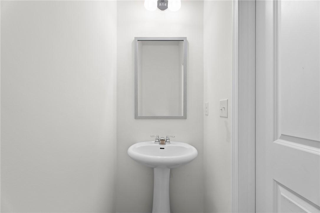 Modern half-bath with pedestal sink and mirror in The Stella D floor plan by Evermore Homes at Silver Oak in Cusseta, AL.
