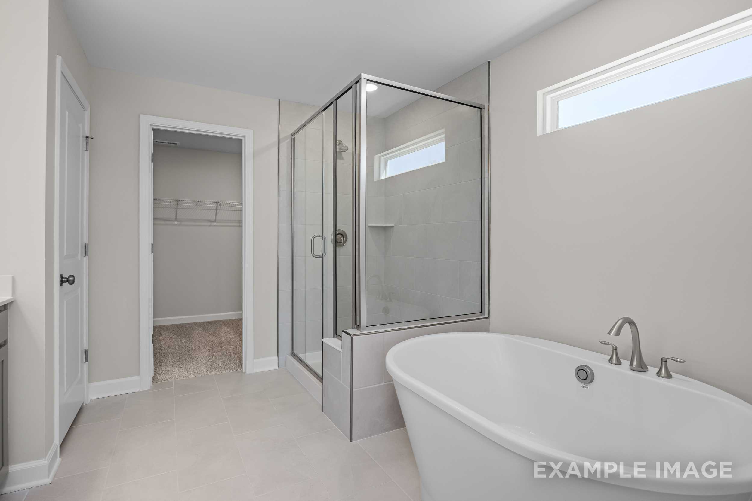 Spacious master bathroom in The Hickory II featuring freestanding tub, glass shower enclosure, and modern vanity
