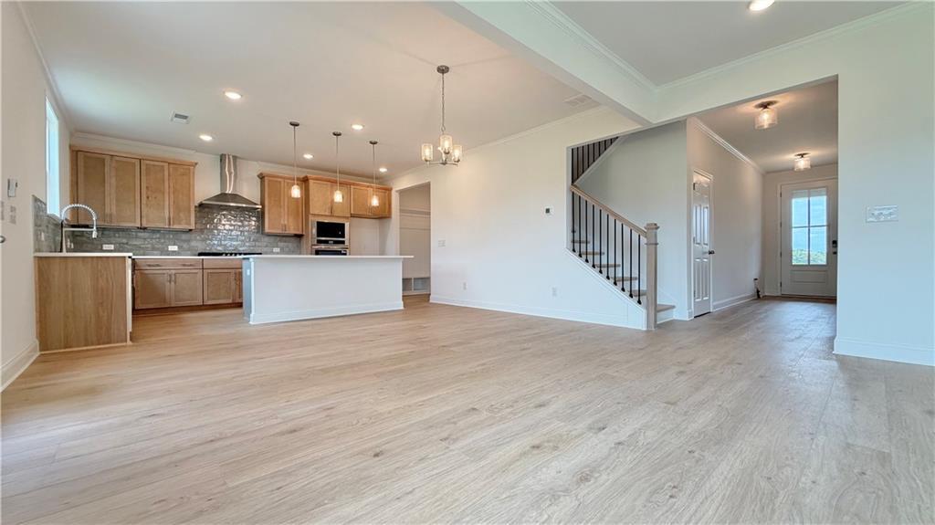 Open-concept kitchen and living area with hardwood floors in The Hickory C floor plan by Davidson Homes in Hoschton, GA.