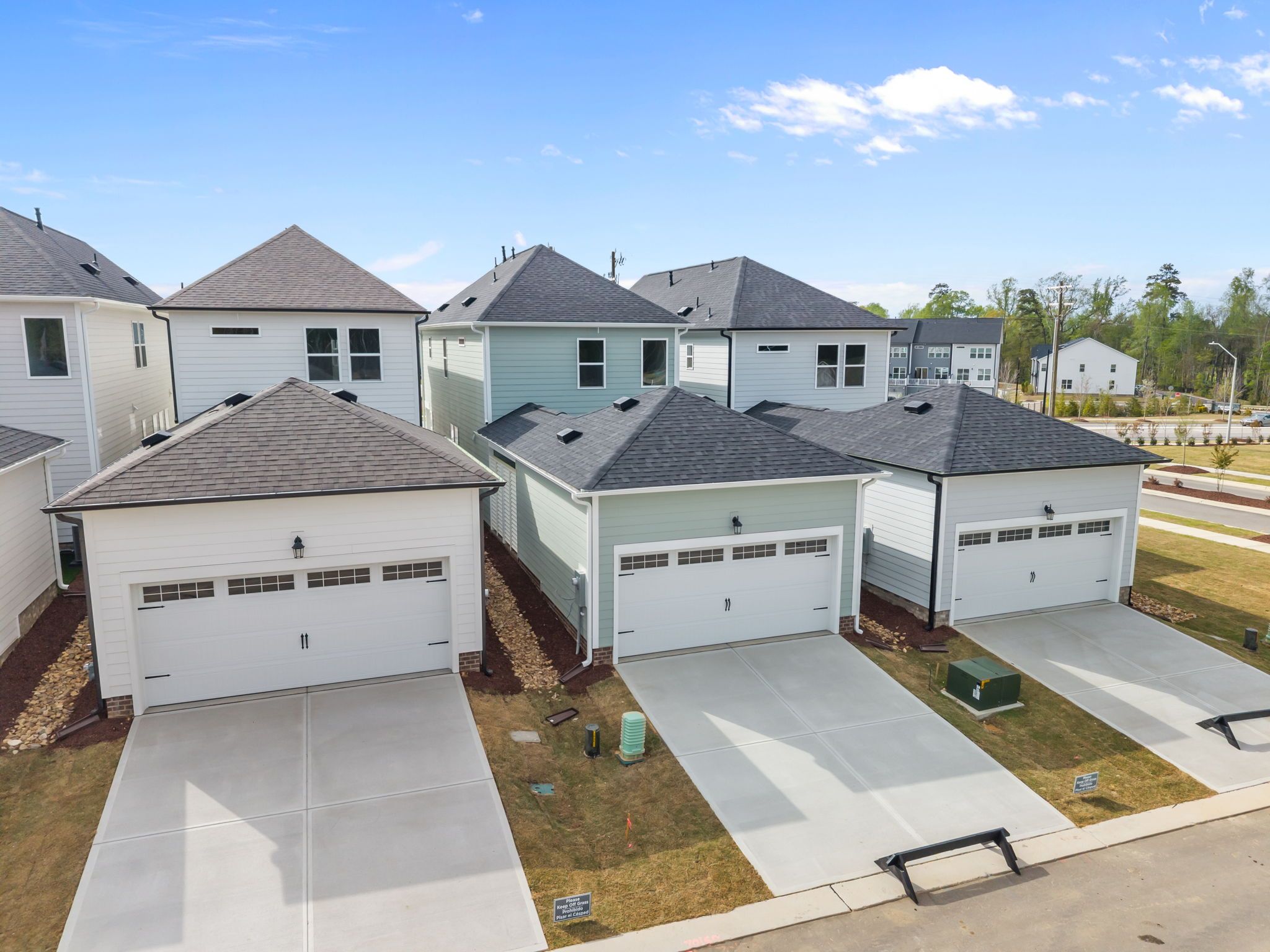 Aerial view of modern townhomes at Forestville Yard in Knightdale NC with attached garages, driveways, and landscaped yards