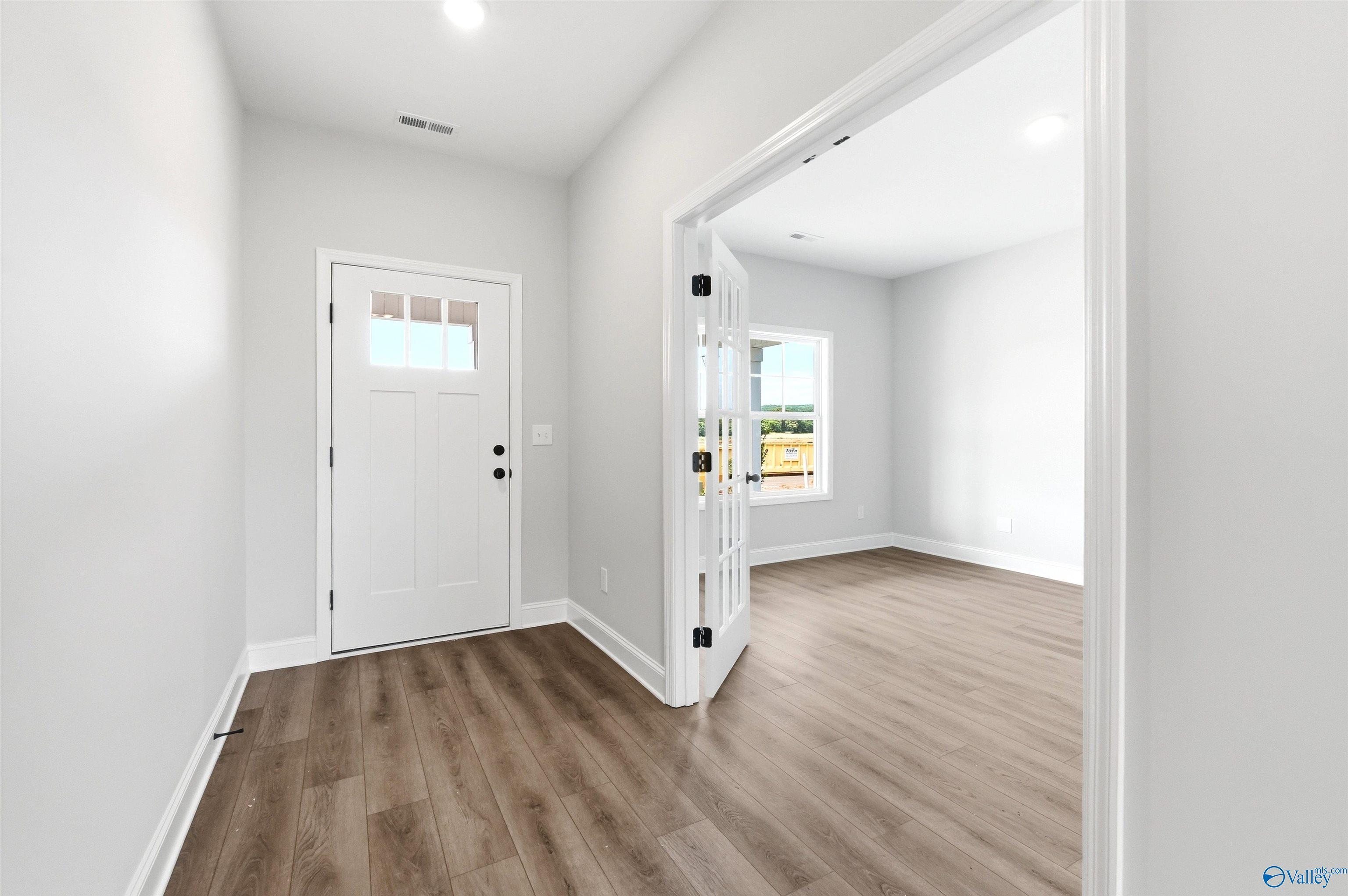 Bright home office with French doors and wood-look floors in The Chelsea D floor plan at Berry Cove in New Market, AL.