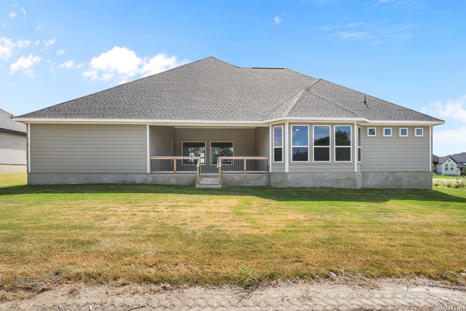 Rear exterior view of The Summerlin B home by Davidson Homes with a covered patio in Potranco Oaks, Castroville, Texas.