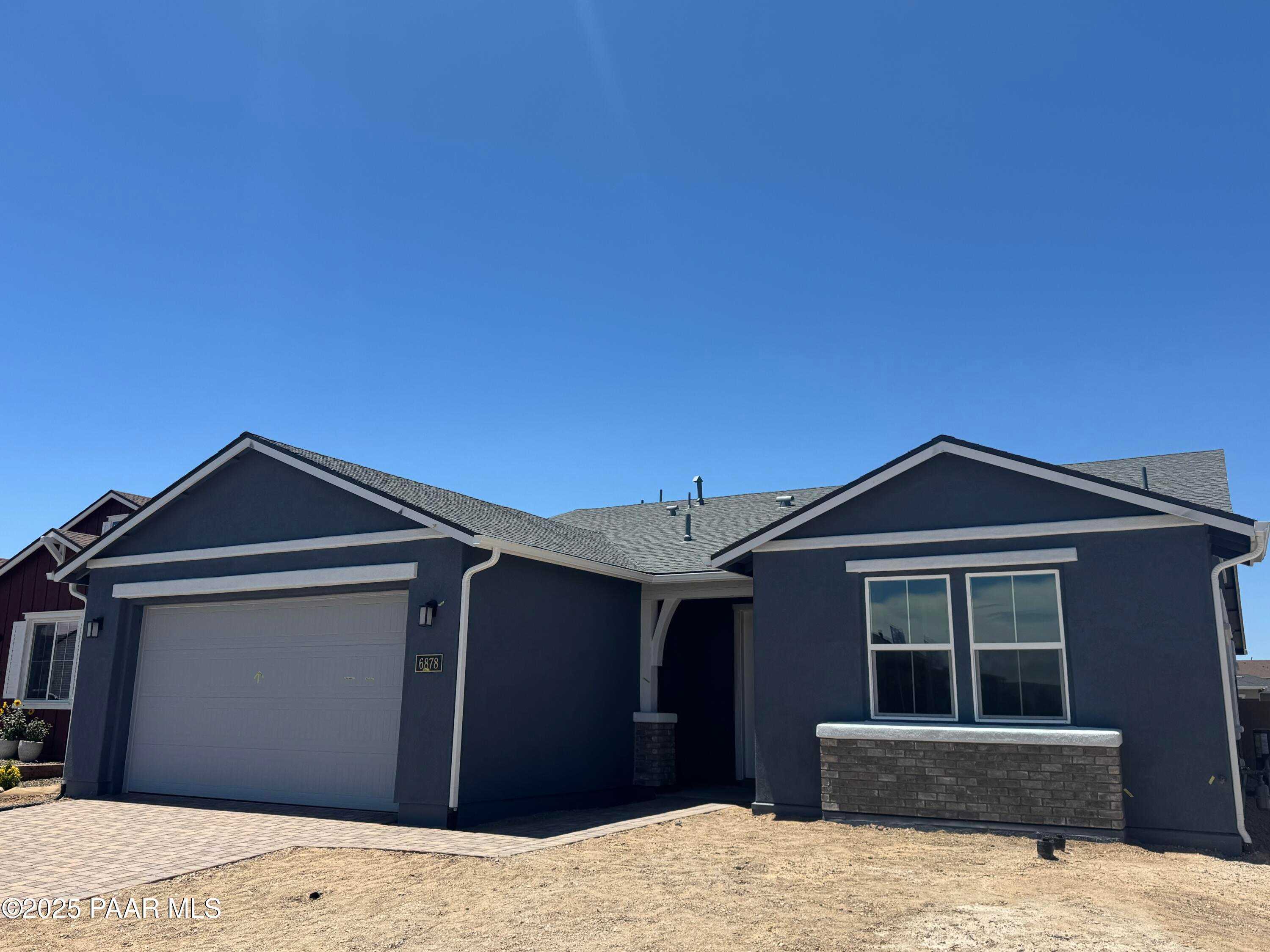 Single-story gray home with 3-car garage, gabled roof, and desert landscaping in Westwood, Prescott, Arizona - Davidson Homes Durango II A