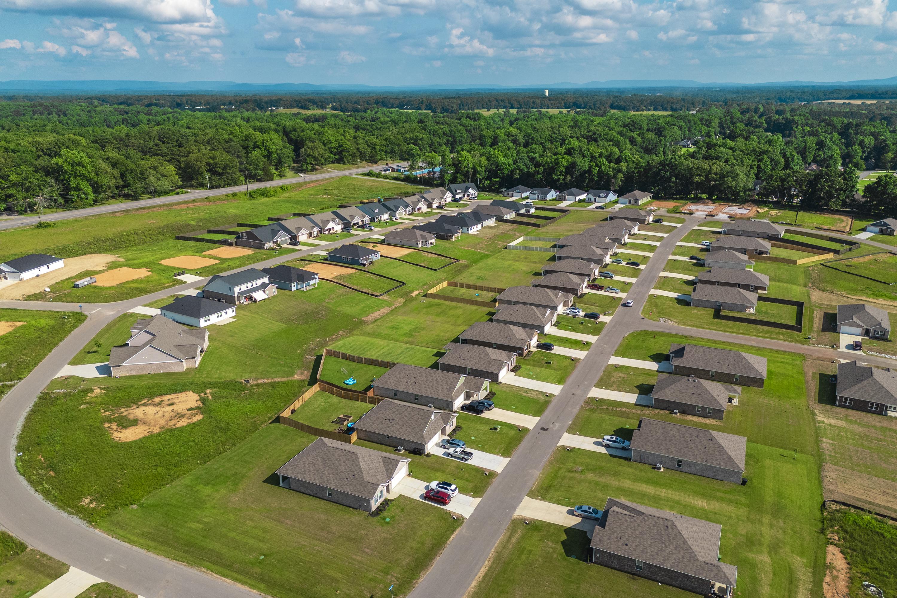Aerial view of new single-family homes in Bailey Park, Fayetteville TN by Davidson Homes amid green lawns and wooded surroundings