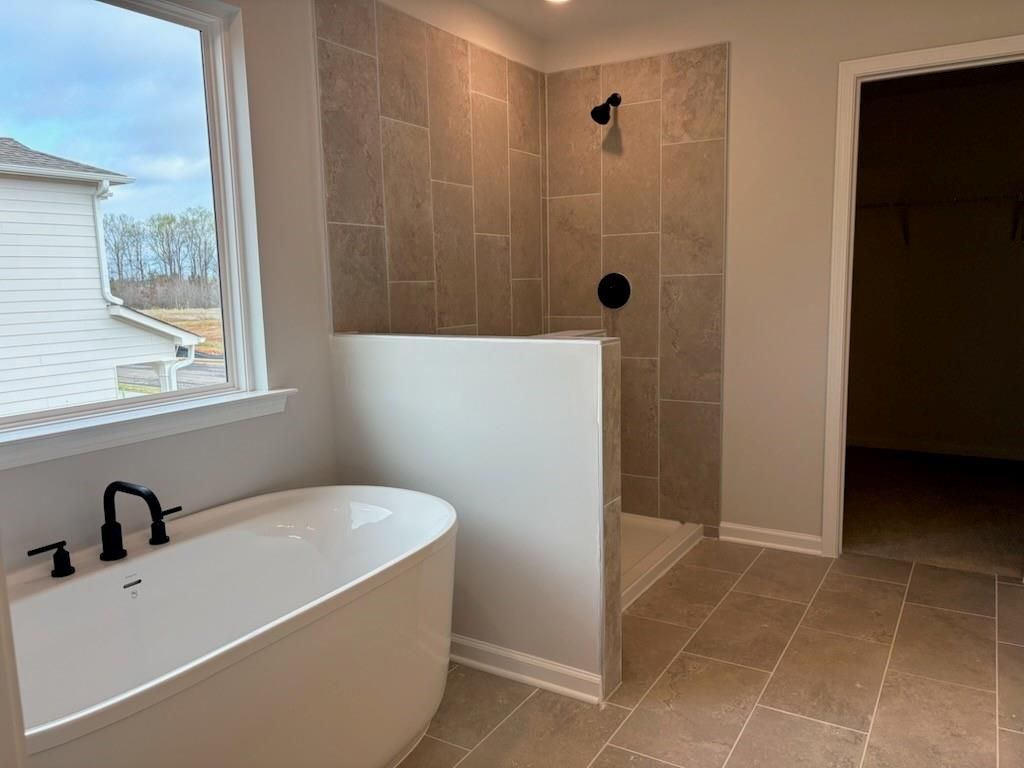 Elegant master bathroom with freestanding tub and tiled walk-in shower in Davidson Homes The Hickory B, Winder, Georgia
