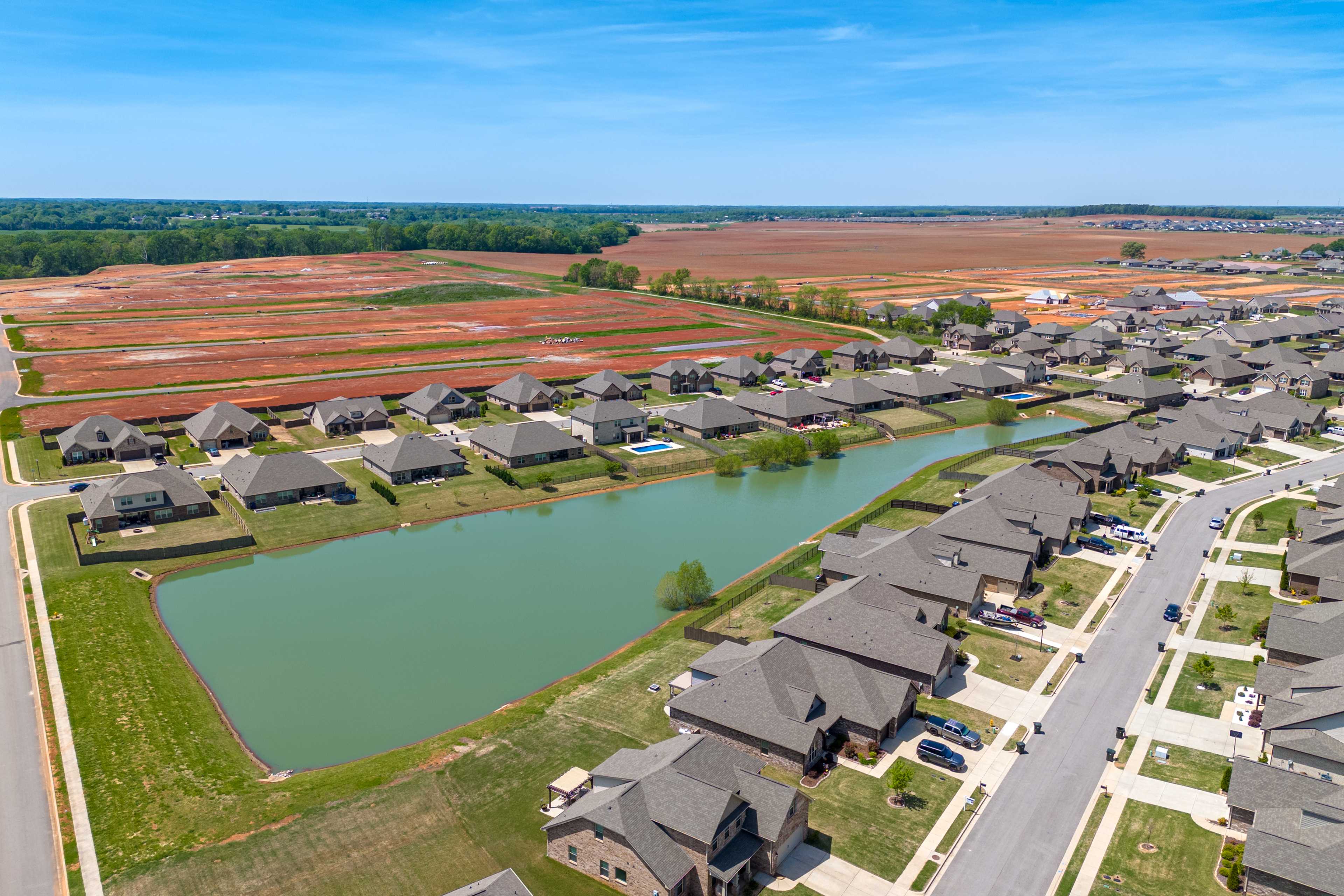 Aerial view of Briercreek neighborhood in Meridianville Alabama with new single-family homes surrounding a serene pond and adjacent fields