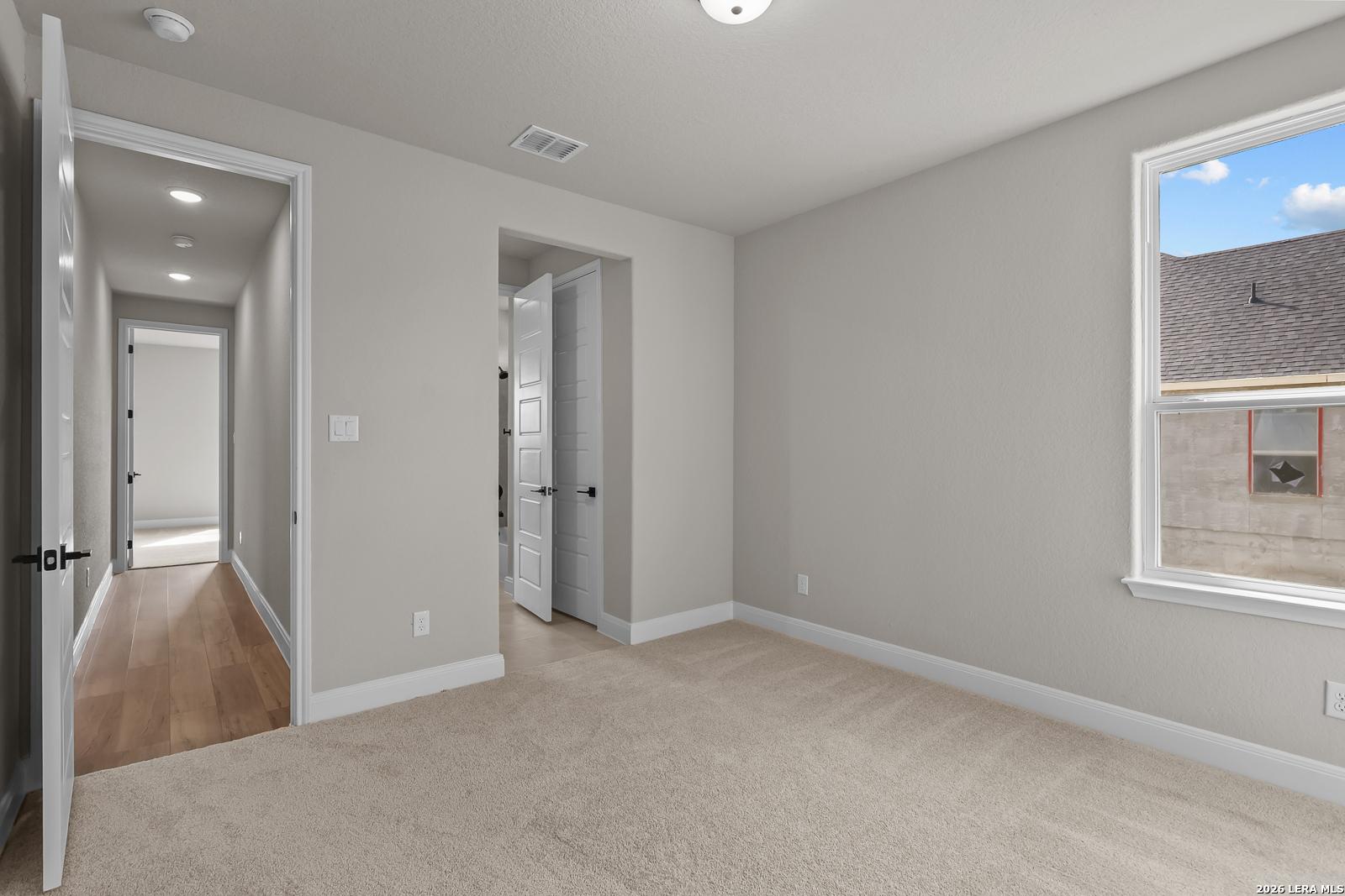 Bright bedroom with carpet flooring and window in Davidson Homes The Foster E 3-bedroom plan, Potranco Oaks, Castroville, Texas