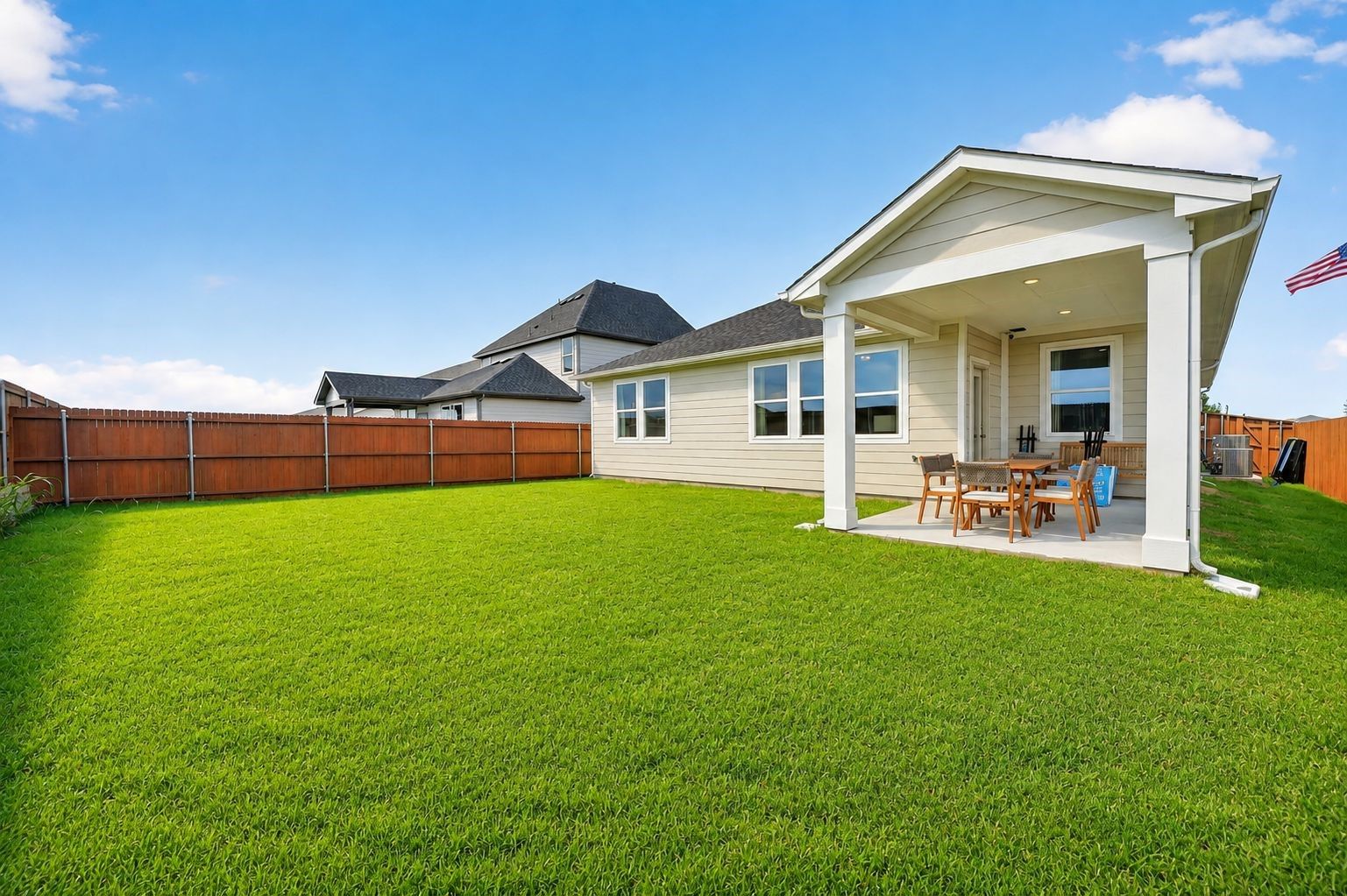 Covered back patio and spacious green backyard of The Laurel I floor plan by Davidson Homes in Heartland, Texas.