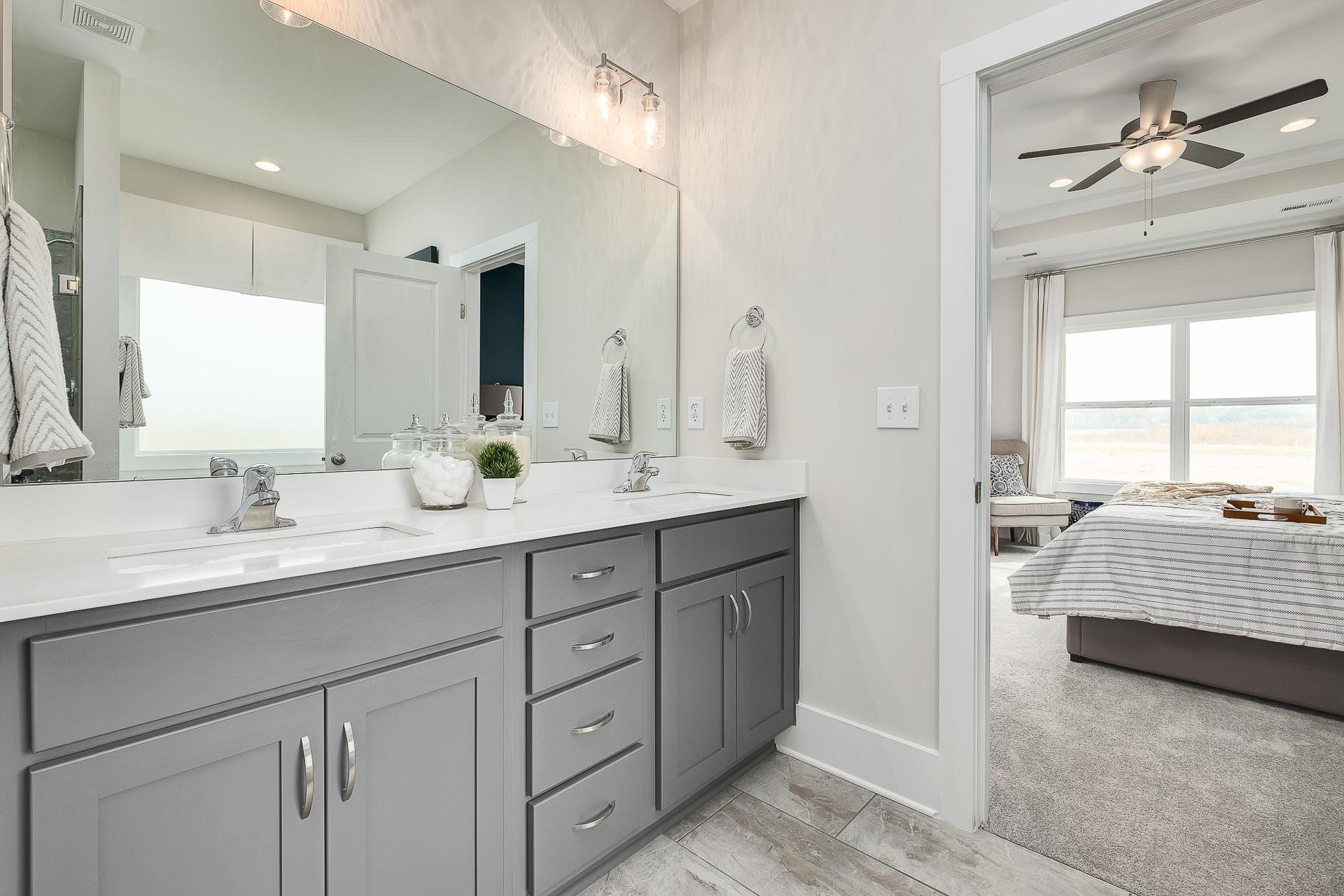 Spacious master bathroom in The Everett with double gray vanity, quartz counters, and bedroom view