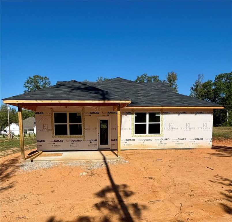 New construction 4-bedroom single-story home with covered front porch, dark shingle roof, and large windows in Silver Oak, Cusseta, Alabama by Evermore Homes