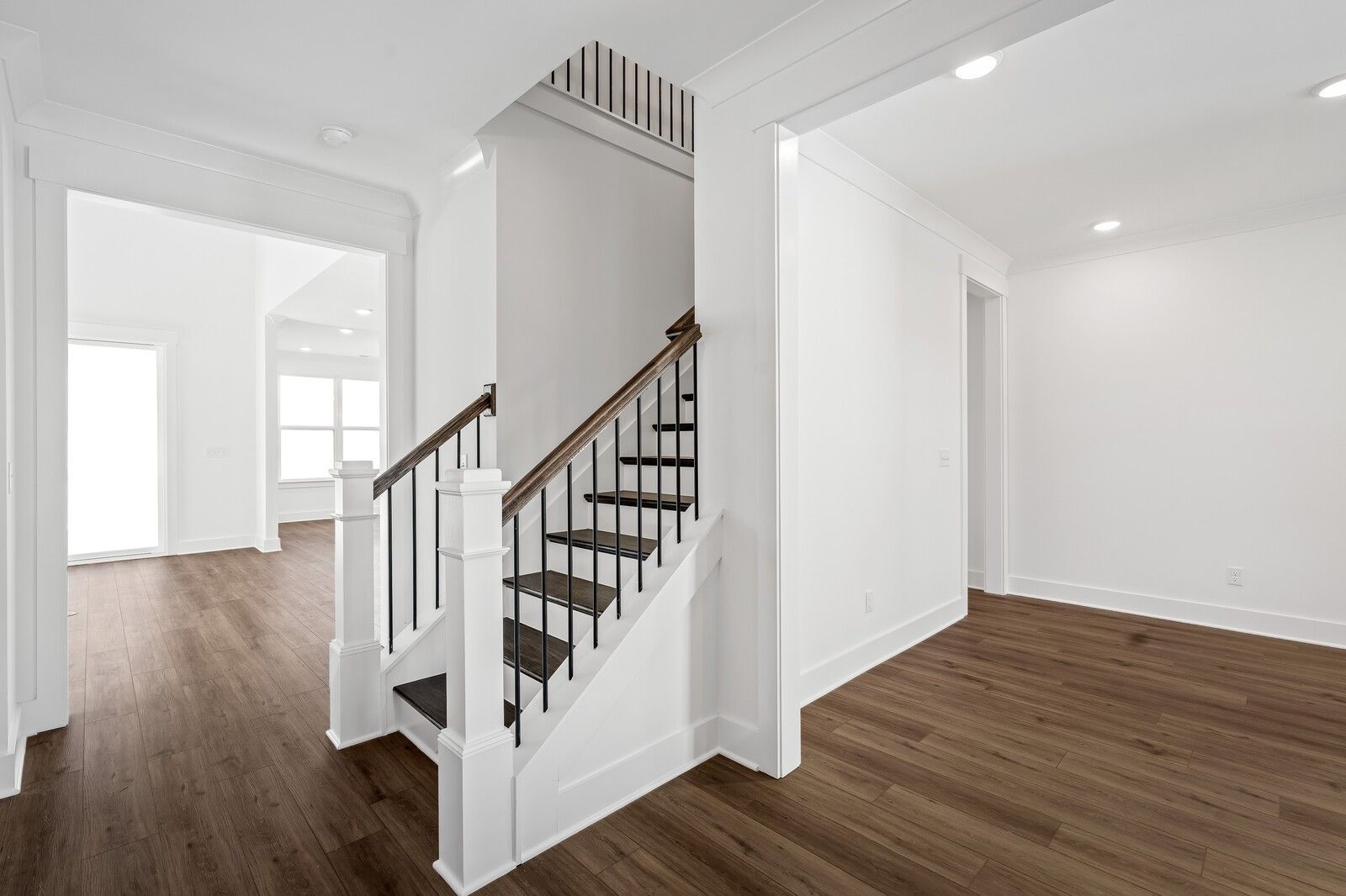 Elegant wooden staircase with iron balusters in open foyer, hardwood floors, The Hawkins 4-bedroom home by Davidson Homes, Murfreesboro, TN