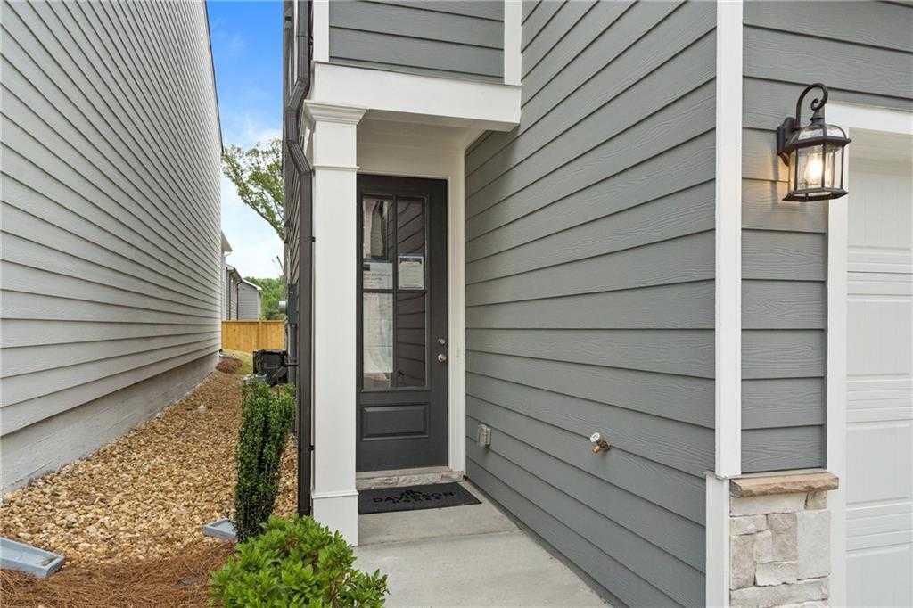 Modern gray two-story home exterior with black glass-front door, white columns, lantern light, and 2-car garage in Kennesaw, Georgia