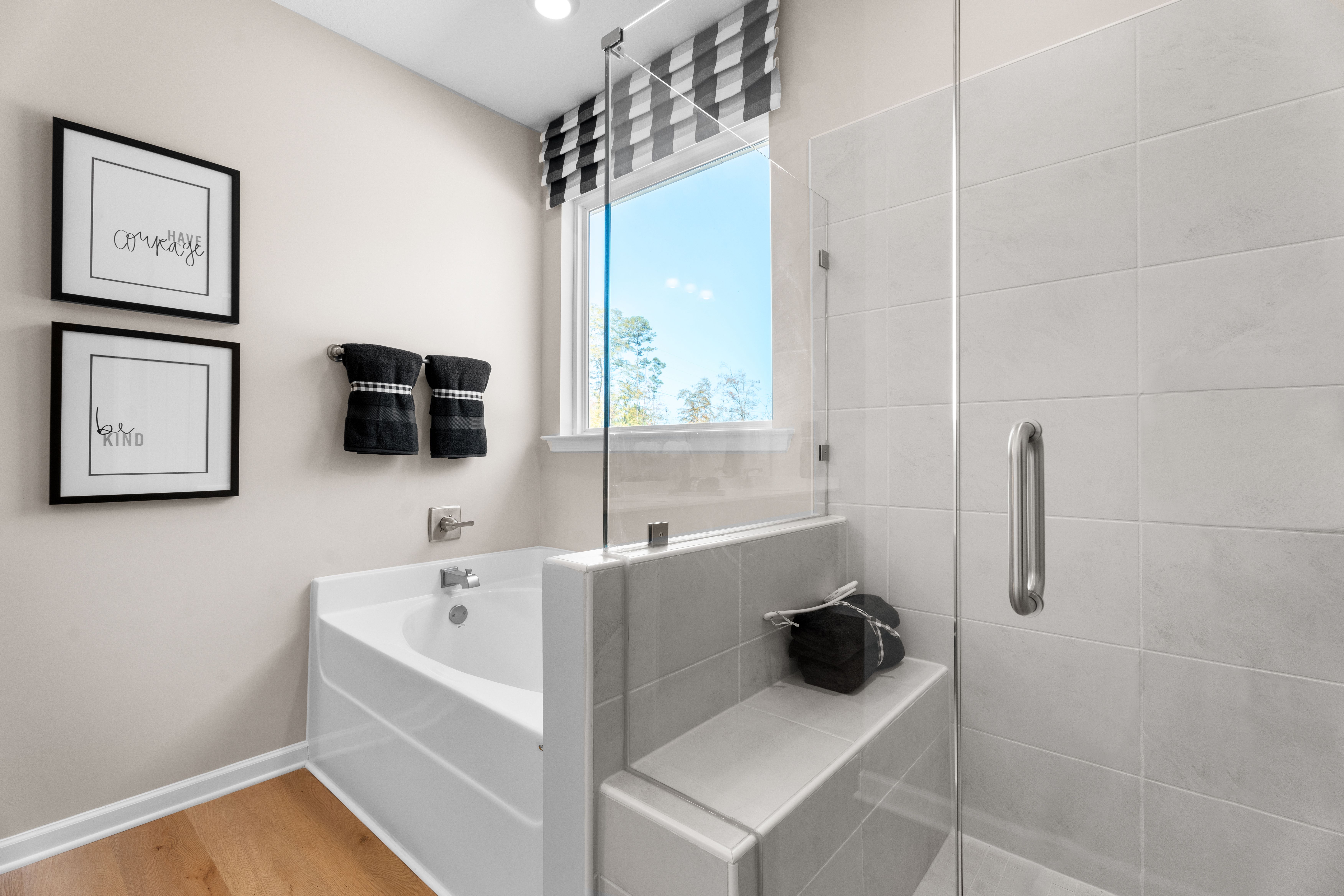 Spacious master bathroom in Silver Oak Cusseta Alabama with white tub glass shower checkered valance by Evermore Homes